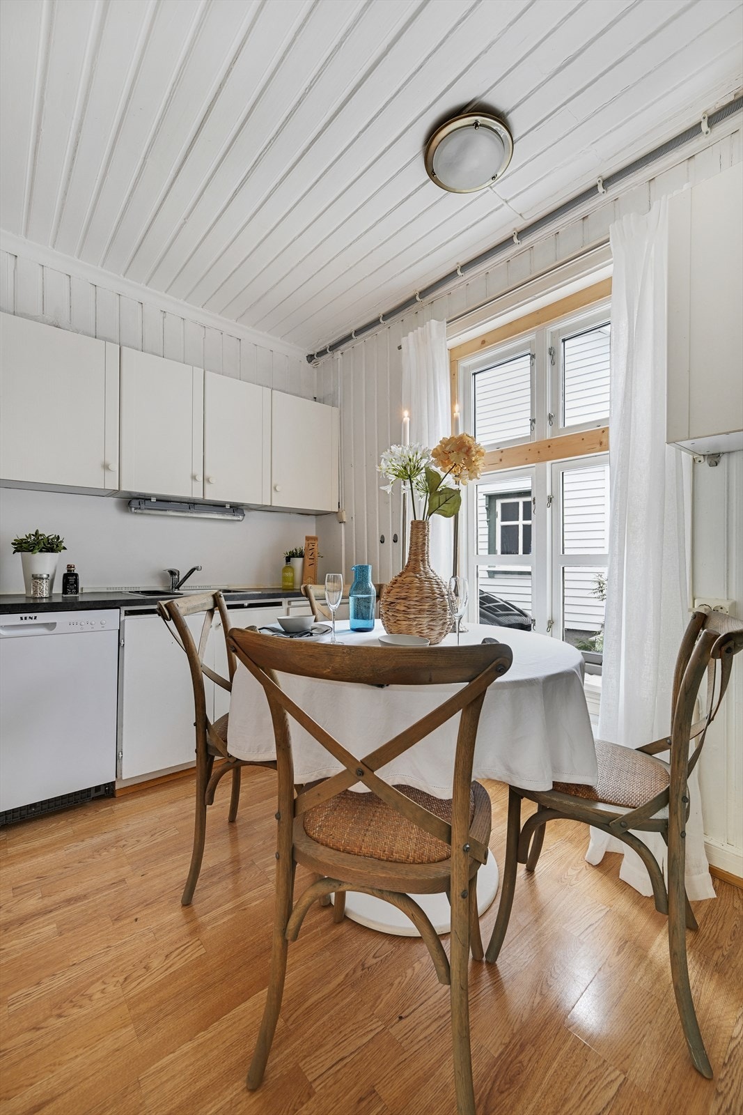 Kjøkken med lys innredning og opplegg for oppvaskmaskin. Galleribilde