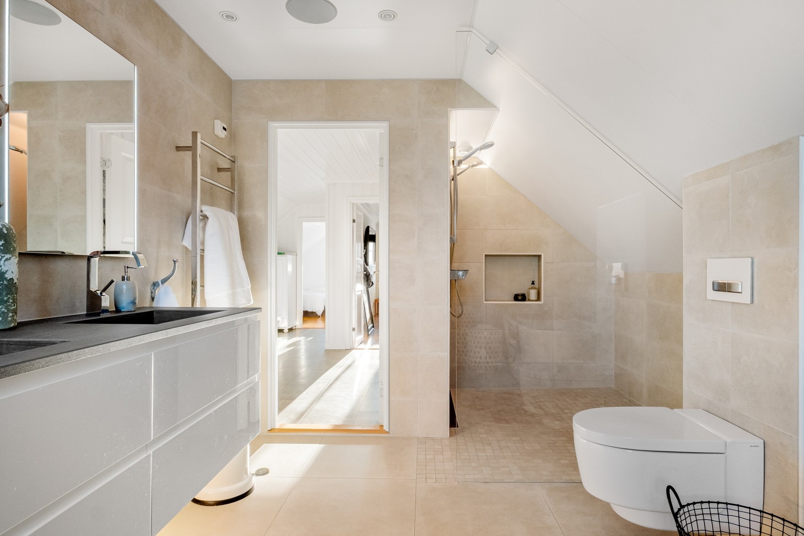 Badet gir en eksklusiv spa-følelse med to dusjer, dobbel servant, badekar, elektrisk håndkletørker, integrerte takhøyttalere og lekre fliser. Galleribilde