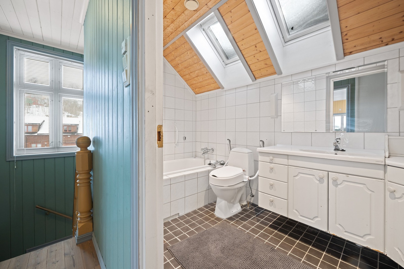 Flislagt baderom i andre etasje innredet med badekar, klosett og servant med servantskap. Galleribilde