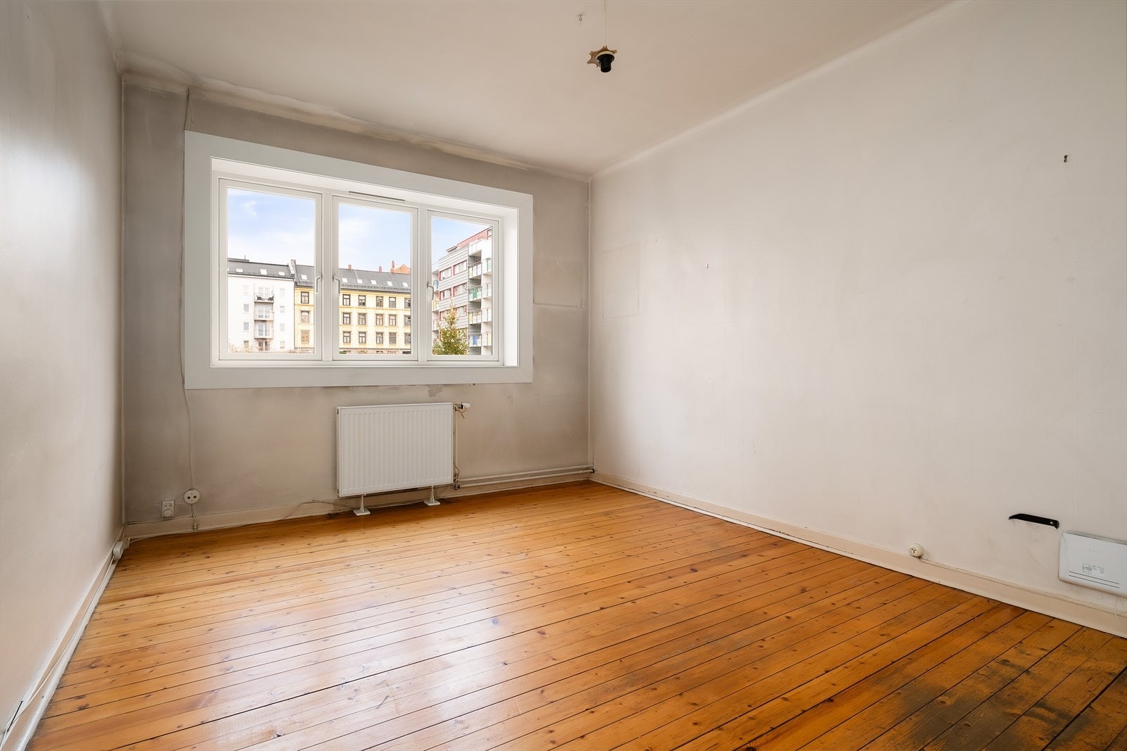 Stuen har originale tregulv som gir karakter, og et stort vindu sørger for rikelig med naturlig lys. Galleribilde