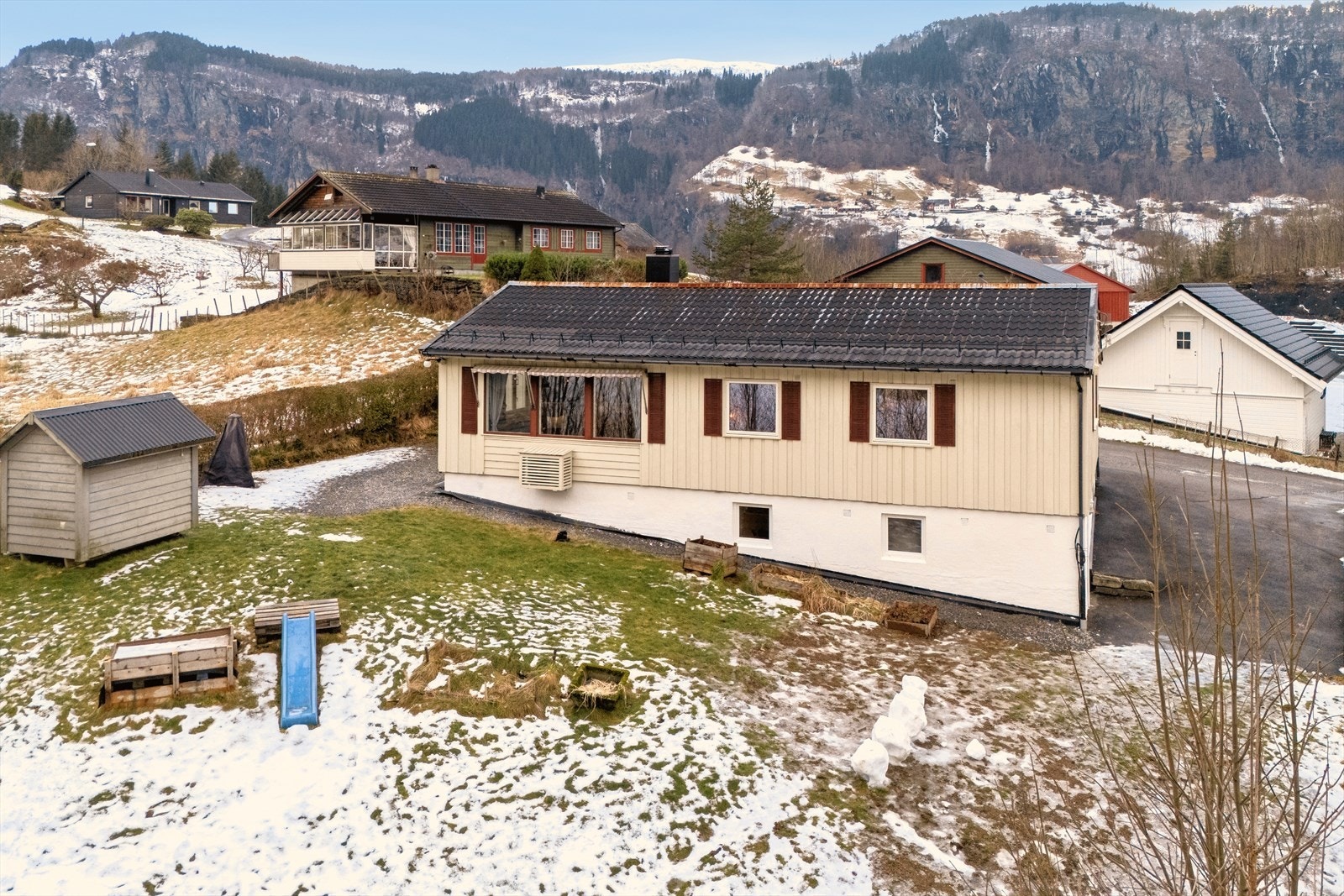 Sentrumsnært og likevel et rolig nabolag med gressplen foran huset. På vestsiden er det klargjort for ny terrasseplatting. Galleribilde