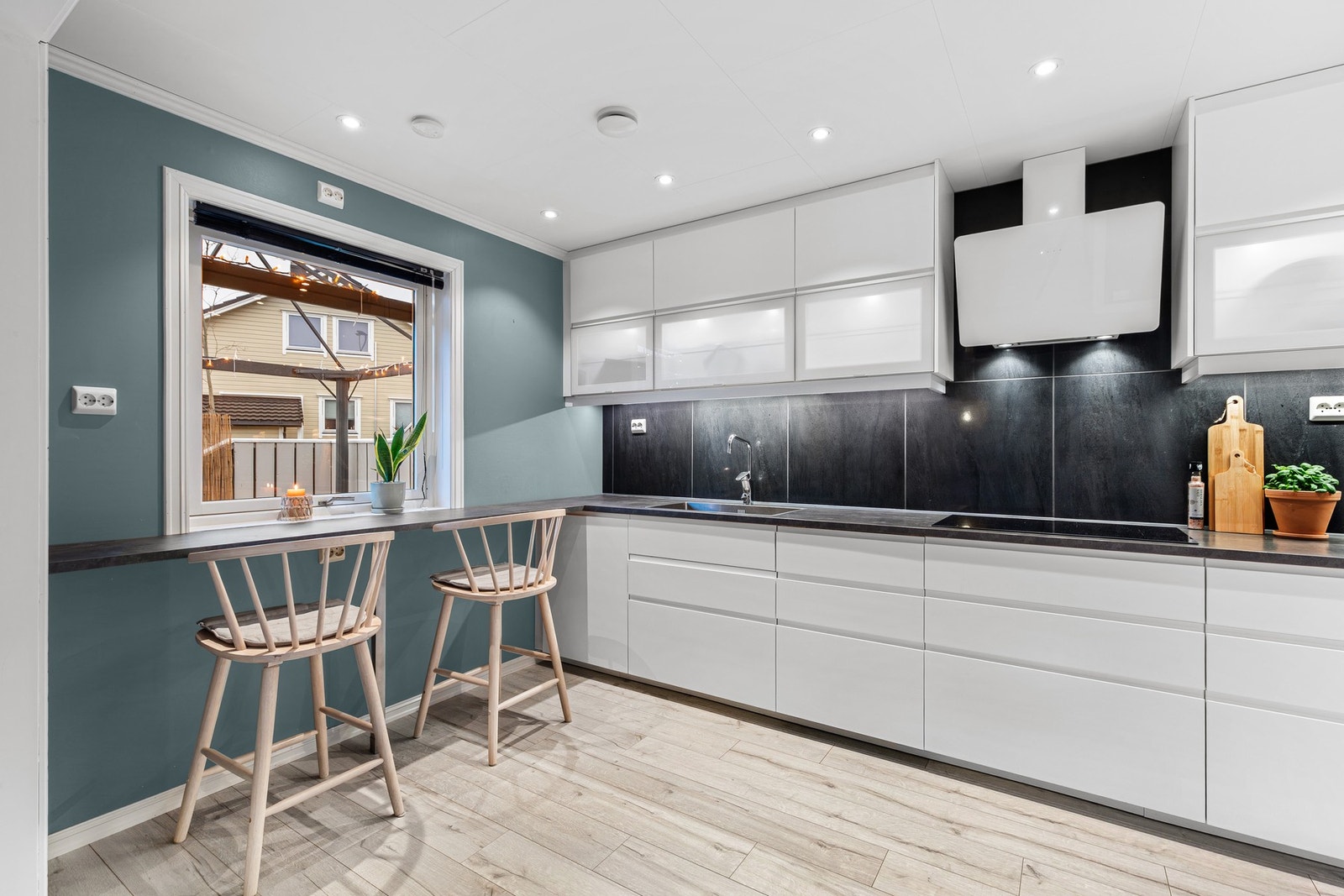 Kjøkkenet har innredning med glatte fronter og benkeplate av laminat Galleribilde