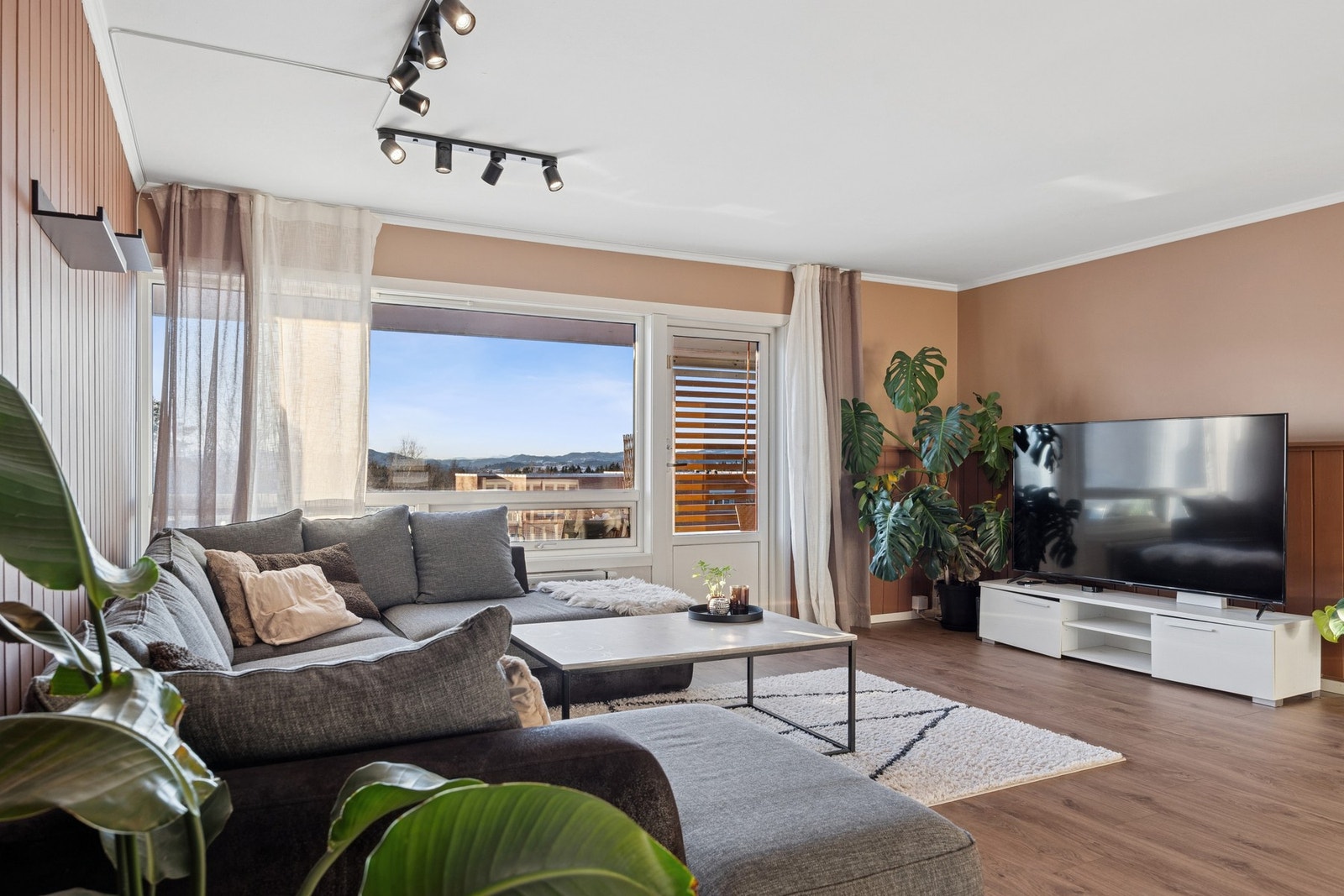 Kombinasjonen av store vinduer, åpen løsning og utgang til uteplass gir stuen en lys og luftig følelse med gode lysforhold gjennom hele dagen. Galleribilde