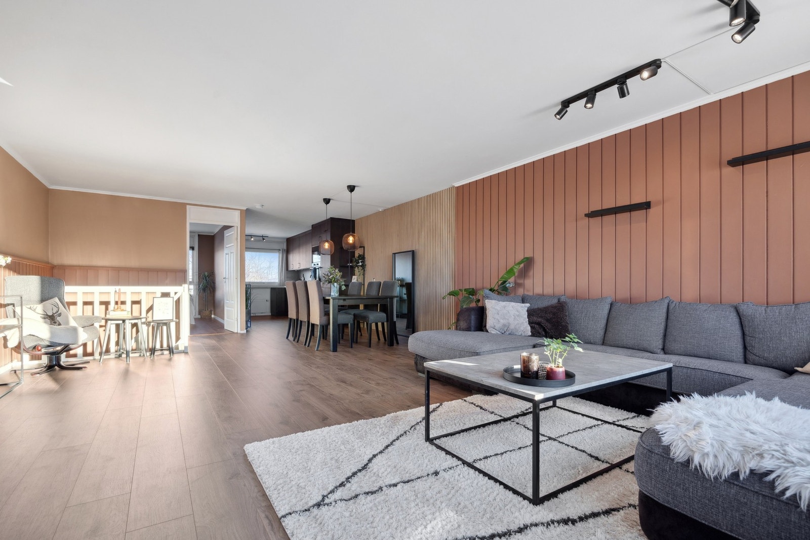 Stuen fremstår som et lyst og romslig oppholdsrom med åpen løsning mot kjøkkenet og store vindusflater som gir rikelig med naturlig lys. Galleribilde