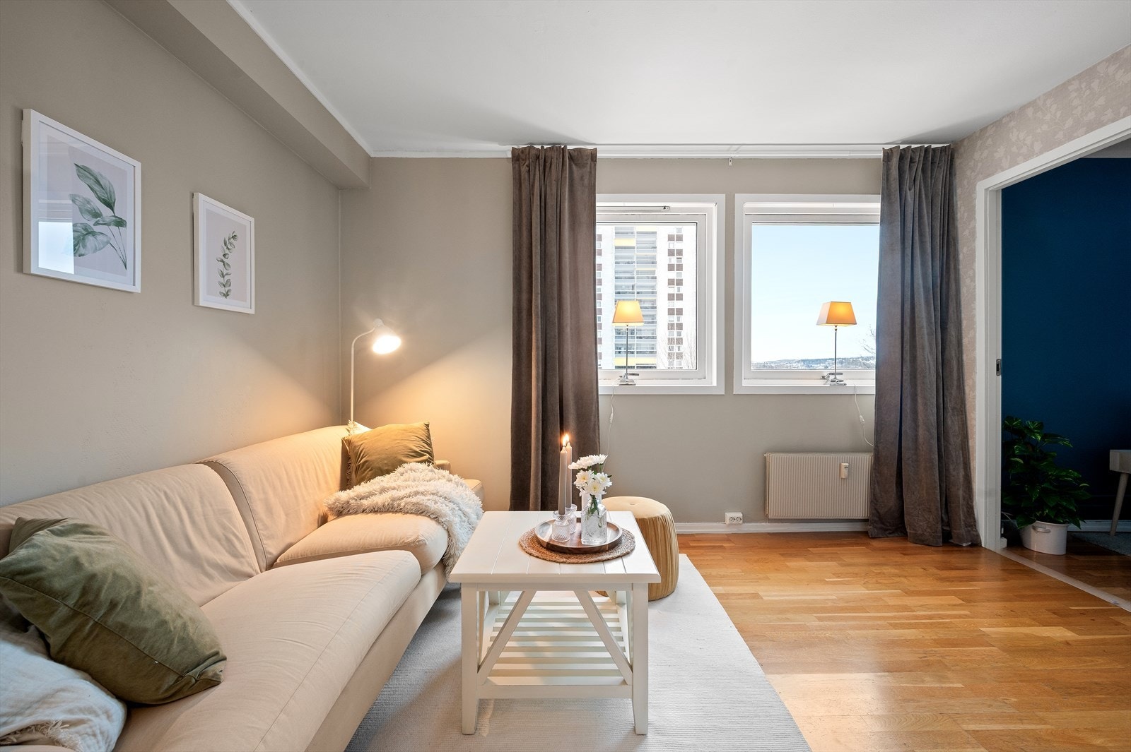 Stuen er malt i lune og behagelige fargetoner og har flott tapet på vegg mot soverom. Galleribilde