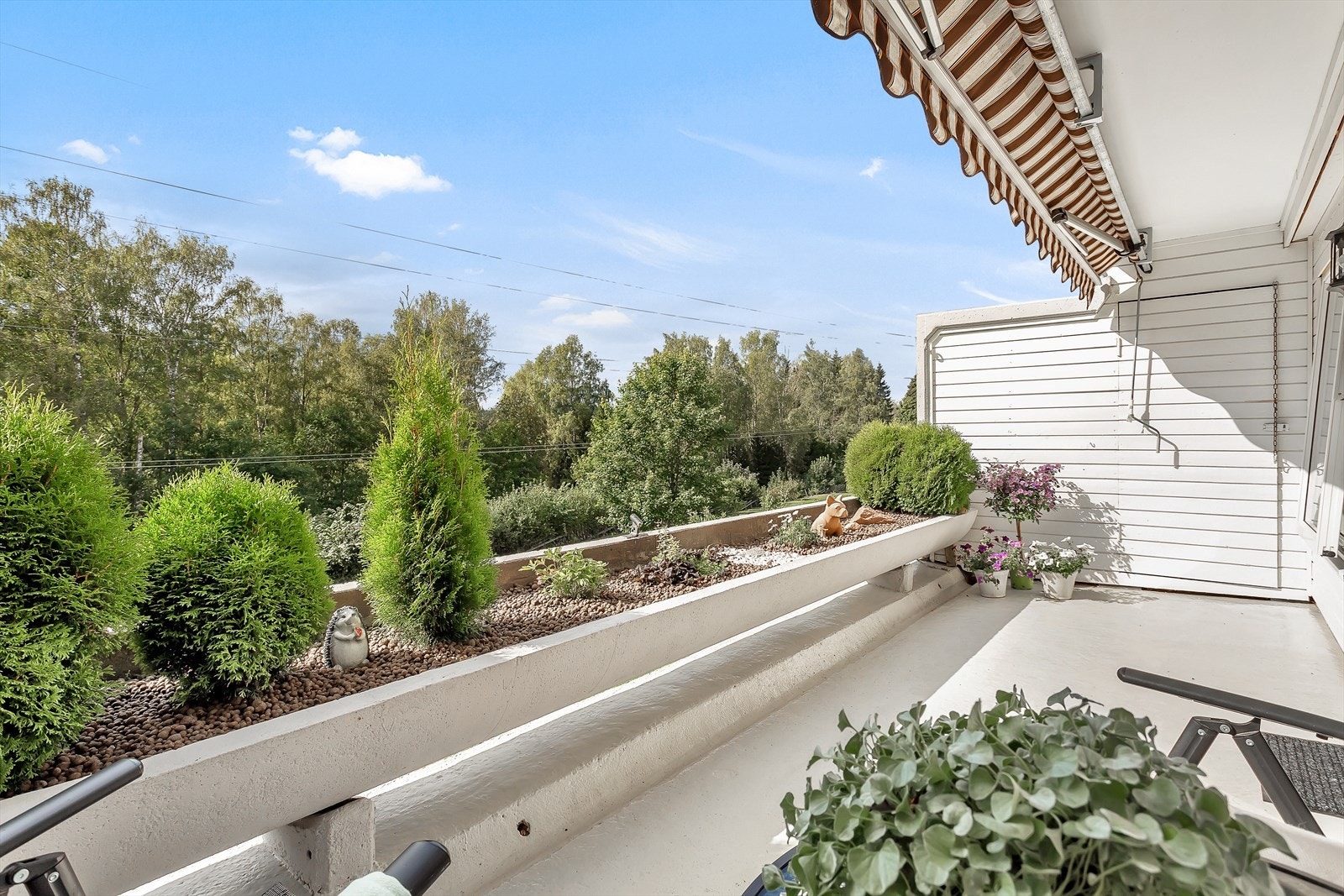 Terrassens rekkverk er en betongkonstruksjon utformet som en dyp blomsterkasse. Galleribilde