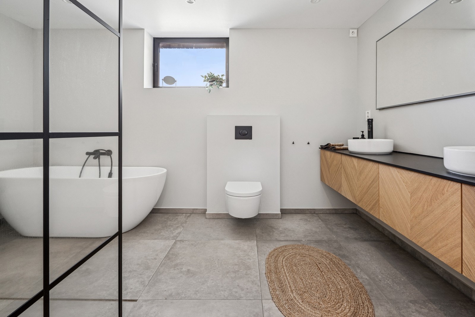 Lekkert og romslig bad med frittstående badekar, moderne innredning og rene linjer. Galleribilde