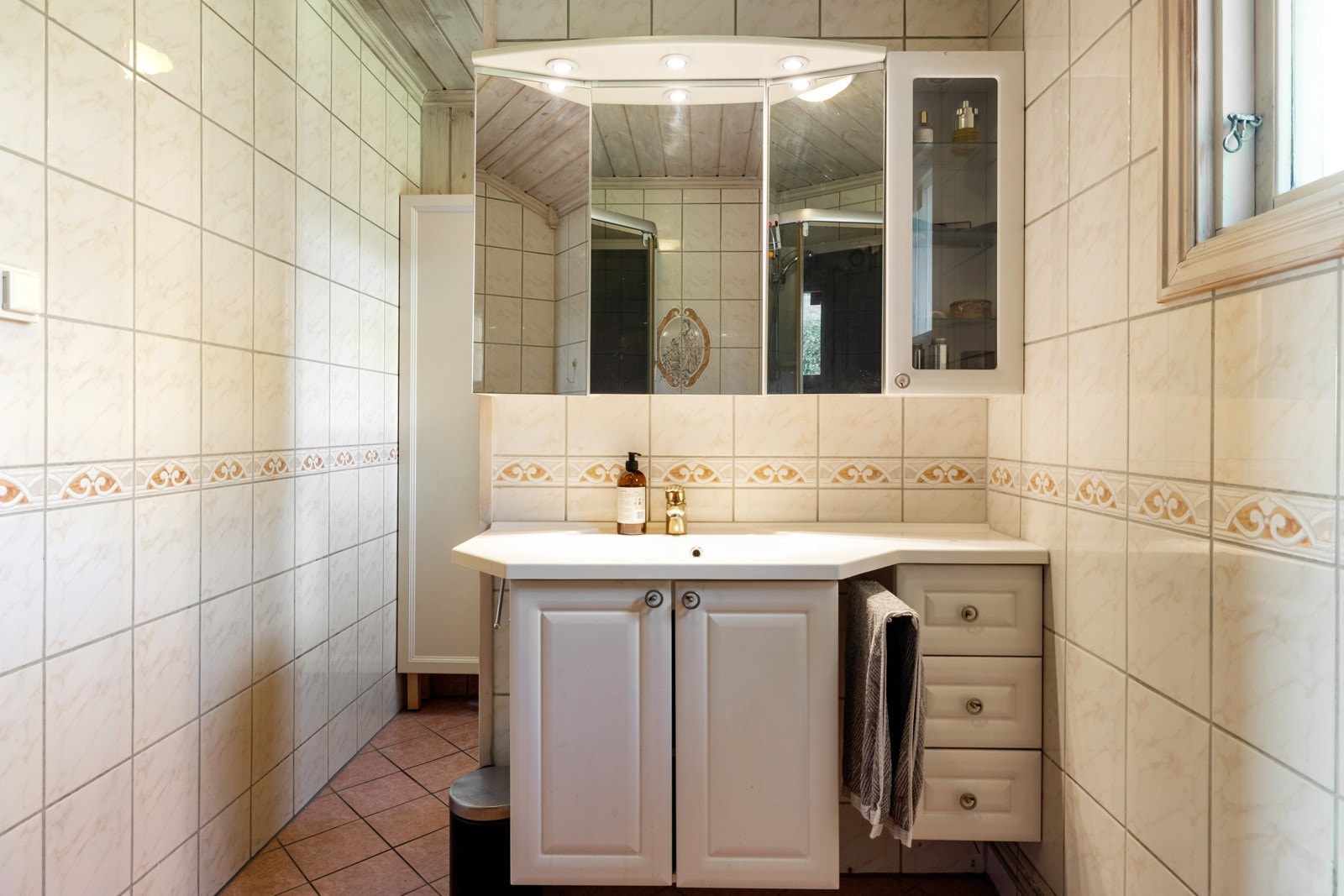 Badet i 1. etasje er flislagt fra 2000 og har en praktisk planløsning. Rommet er innredet med servantinnredning med underskap og god oppbevaringsplass i både skuffer og skap Galleribilde