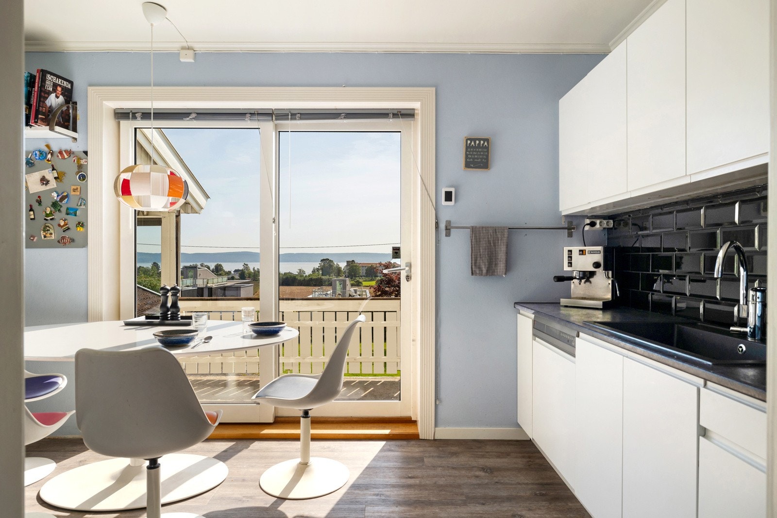 Kjøkkenet fremstår moderne og funksjonelt med hvite, slette fronter som gir et tidløst uttrykk Galleribilde