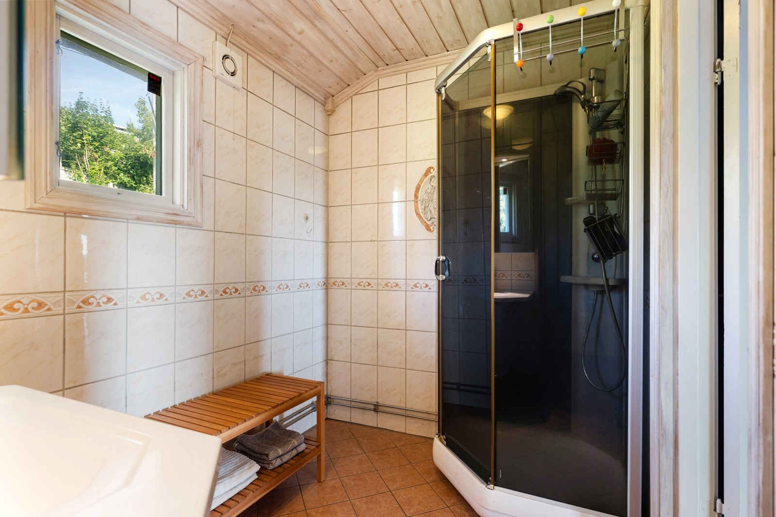 Badet er utstyrt med gulvmontert toalett og et praktisk dusjkabinett. Her er det behagelige varmekabler i gulvet. Galleribilde