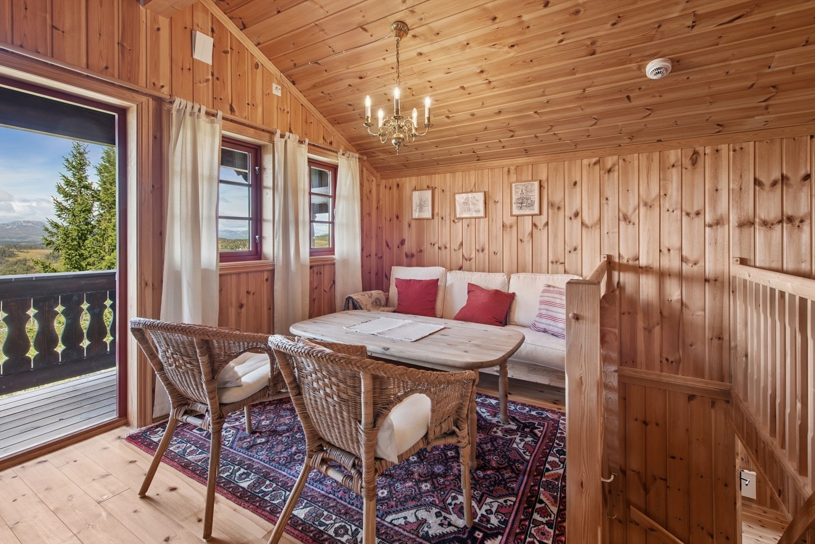 Lyst og trivelig loftsstue med plass til sofagruppe og direkte utgang til overbygget veranda - perfekt for både lufting av dyner og solrike stunder med flott utsikt. Galleribilde