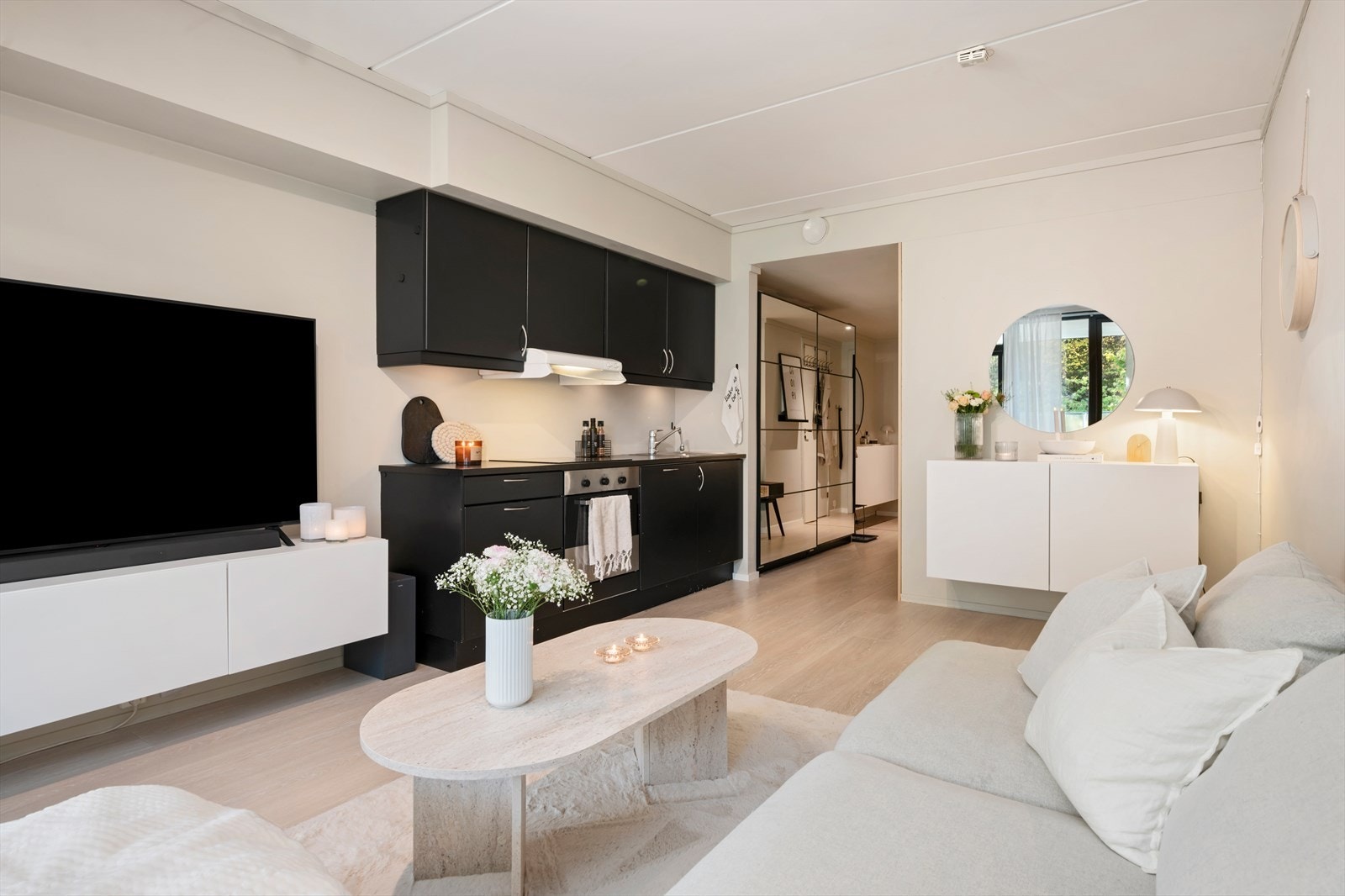 Flott kjøkken med sorte moderne fronter, integrert platetopp, stekovn og oppvaskmaskin. Galleribilde