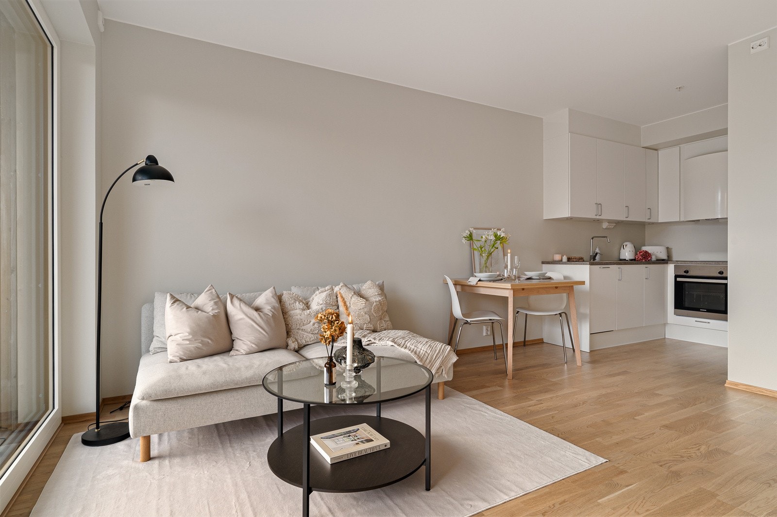 Kjøkkenet er praktisk og moderne, og med hvite, glatte fronter har innredningen et nøytralt og stilrent preg som harmonerer visuelt behagelig med øvrige overflater i rommet. Galleribilde