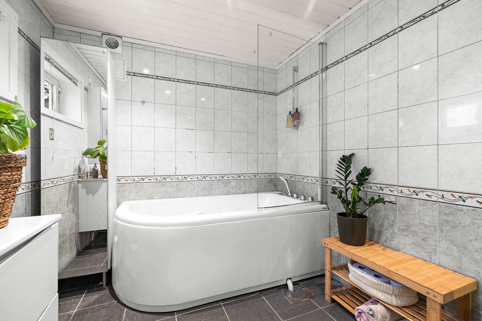 Pent bad med badekar, dusjløsning og flislagte overflater. Galleribilde