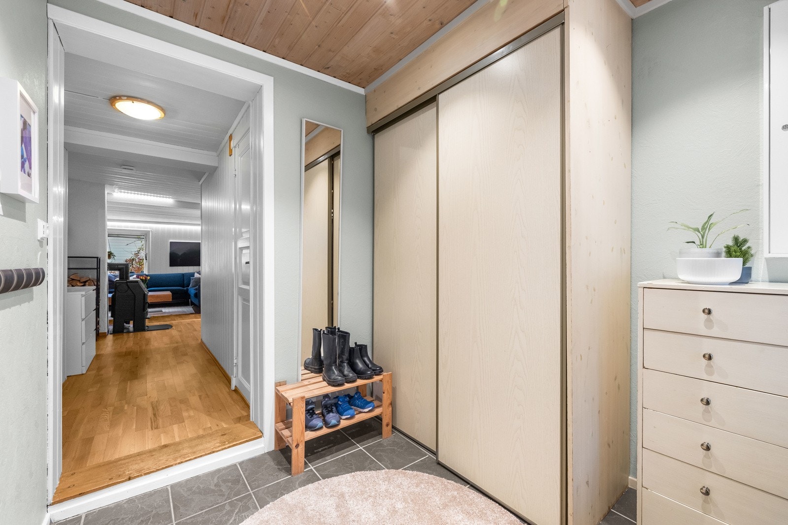 Praktisk entré med flislagt gulv og god lagringskapasitet i skyvedørsgarderobe. Galleribilde