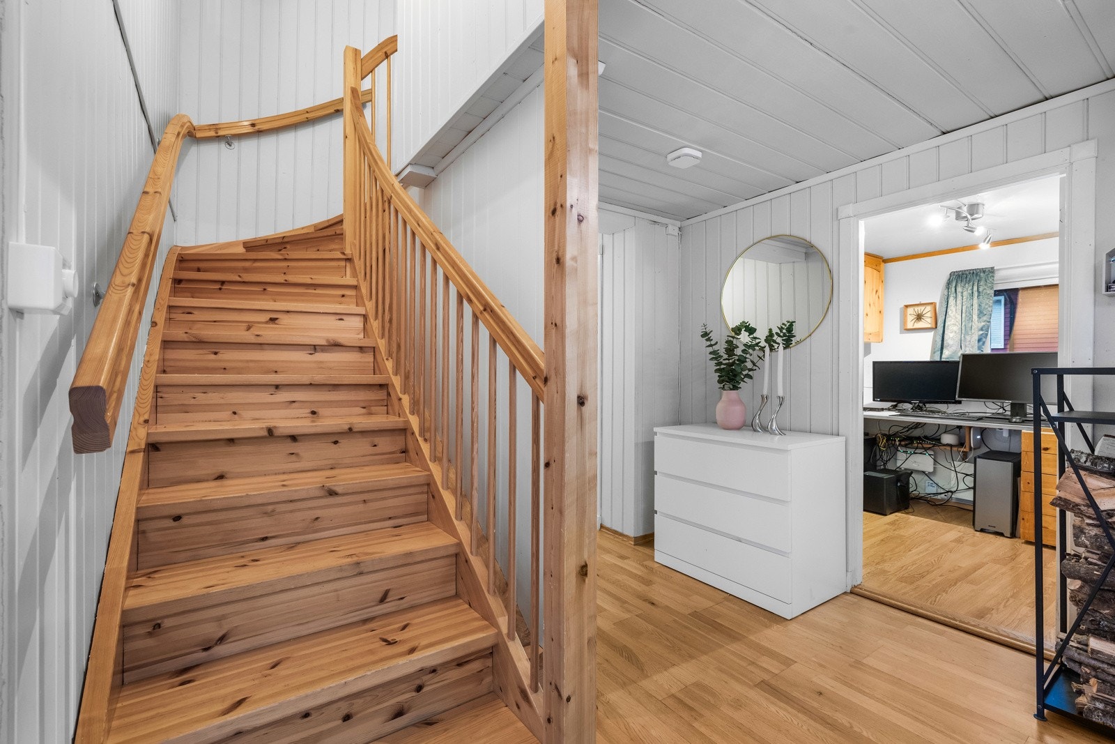 Lys gang med trappeløsning i tre som leder opp til boligens andre etasje, og med praktisk adkomst til tilstøtende rom. Galleribilde