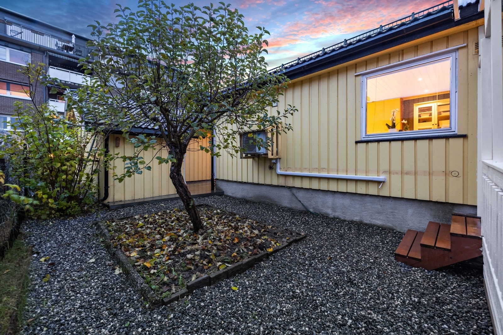 Skjermet hage med opparbeidet gårdsrom og et sjarmerende epletre. Galleribilde