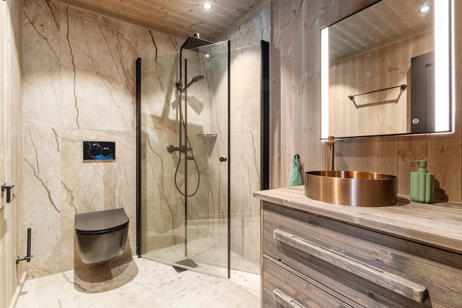 Badet tilhørende hovedsoverommet er pent innredet med dusjvegger, toalett og innredning med servant. I tillegg er det speil med belysning. Galleribilde