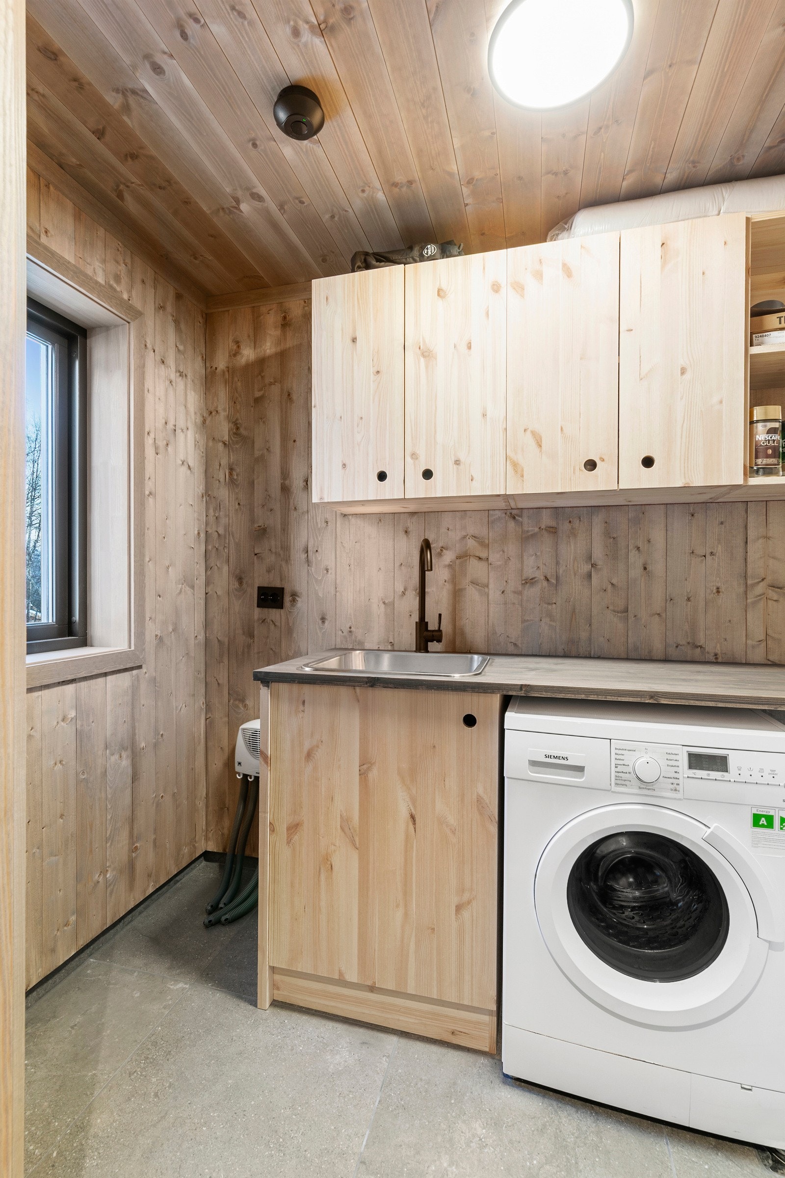 Vaskerommet ligger rett innenfor inngangsdøren. Praktisk og fint med innredning med plass for vaskemaskin. Galleribilde