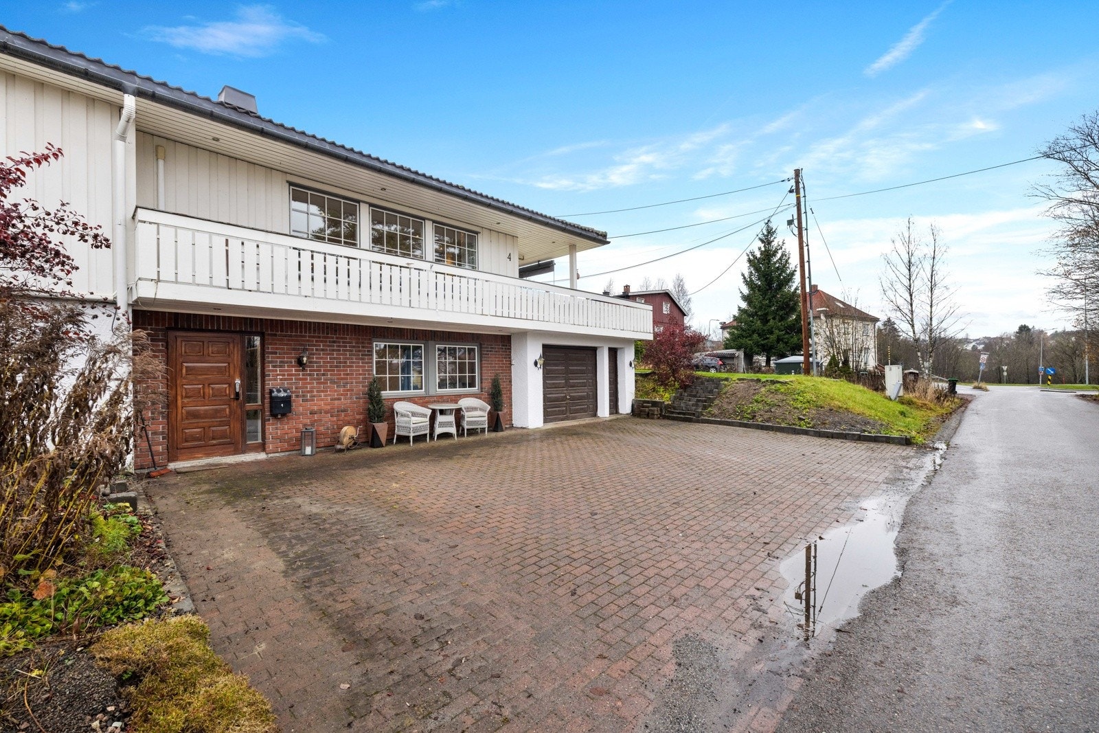 Steinlagt gårdsplass med mulighet for å parkere 4-5 biler iflg. eier. Innkjøring til integrert garasje med elbillader. Galleribilde