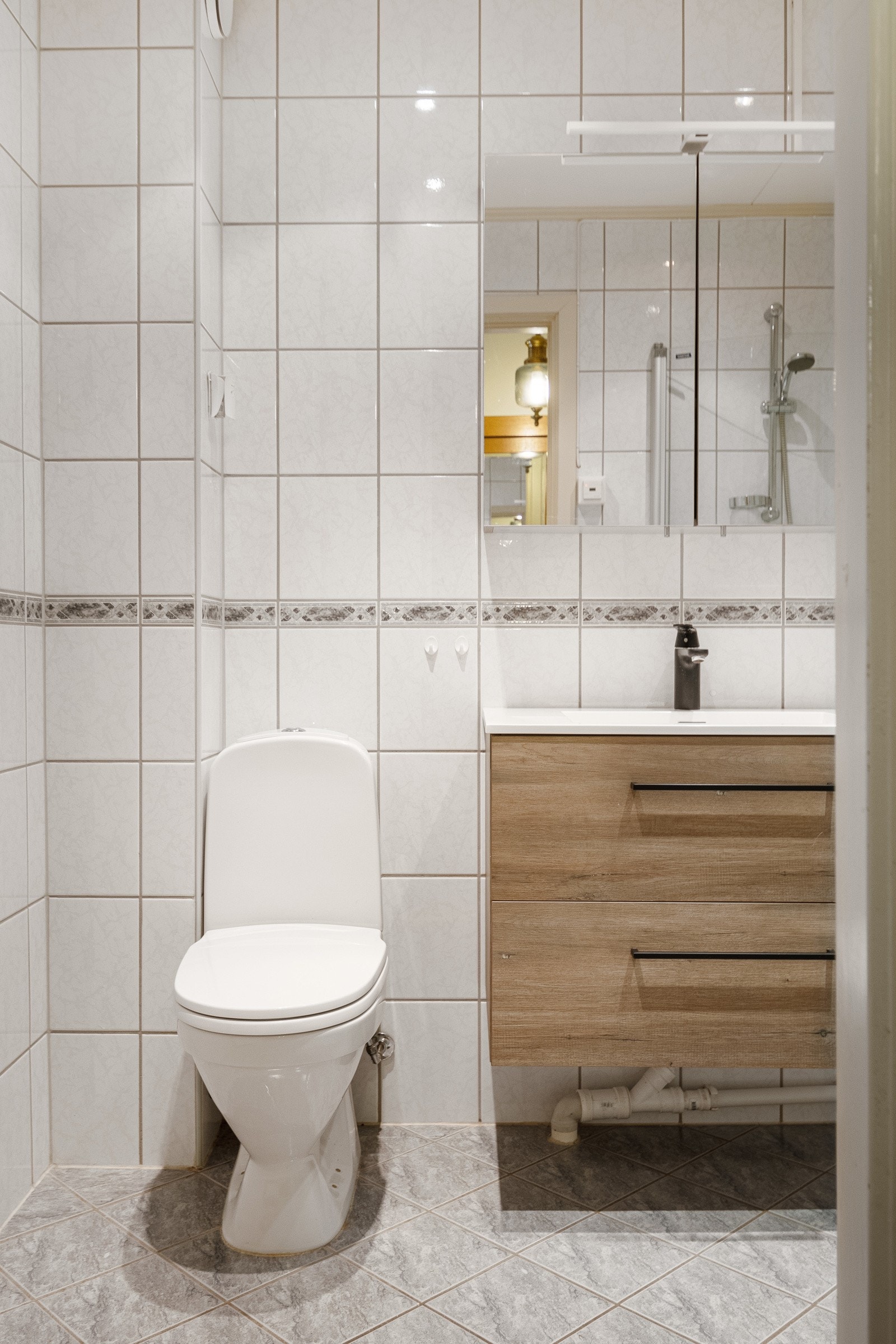 Badet er innredet med toalett, servantinnredning og dusjhjørne. Galleribilde