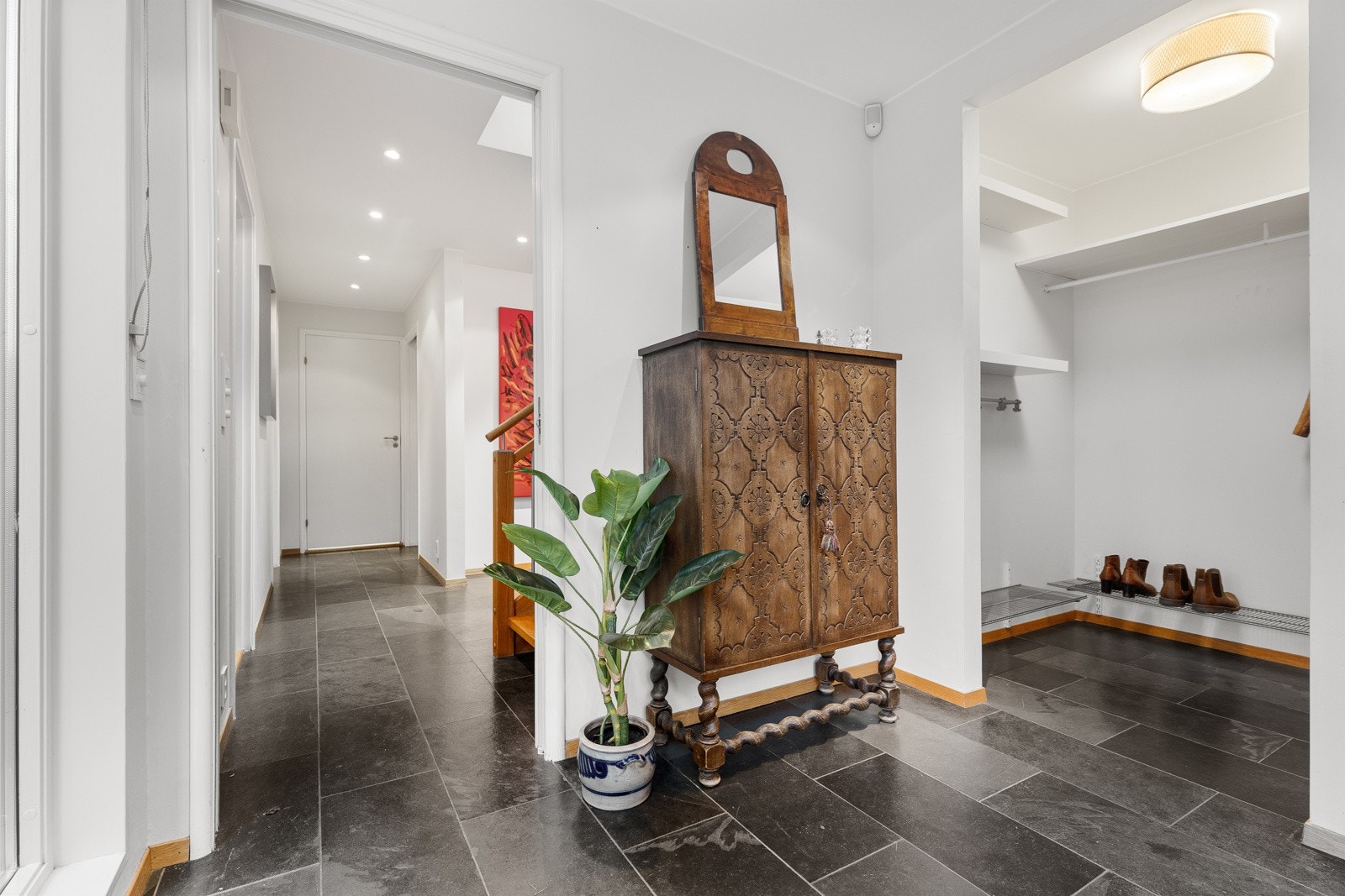 Stor og praktisk inngangssone med egen garderobedel som har god plass til klær og sko Galleribilde