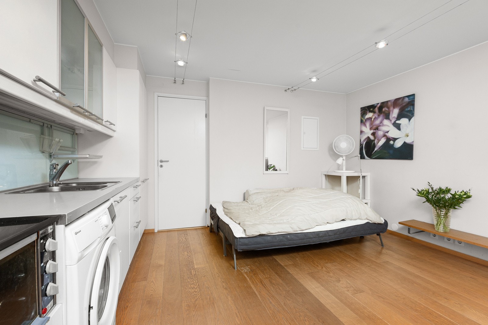 Det er hybelkomfyr, integrert kjøleskap under benken og frittstående vaskemaskin, med mekanisk avtrekk over hybelkomfyren. Galleribilde