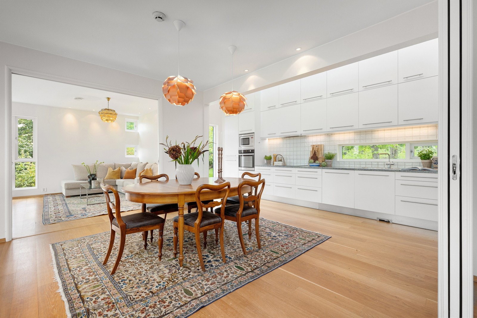 Boligen har tre stuer på rekke, med spisestuen plassert midt i en åpen og lys planløsning Galleribilde