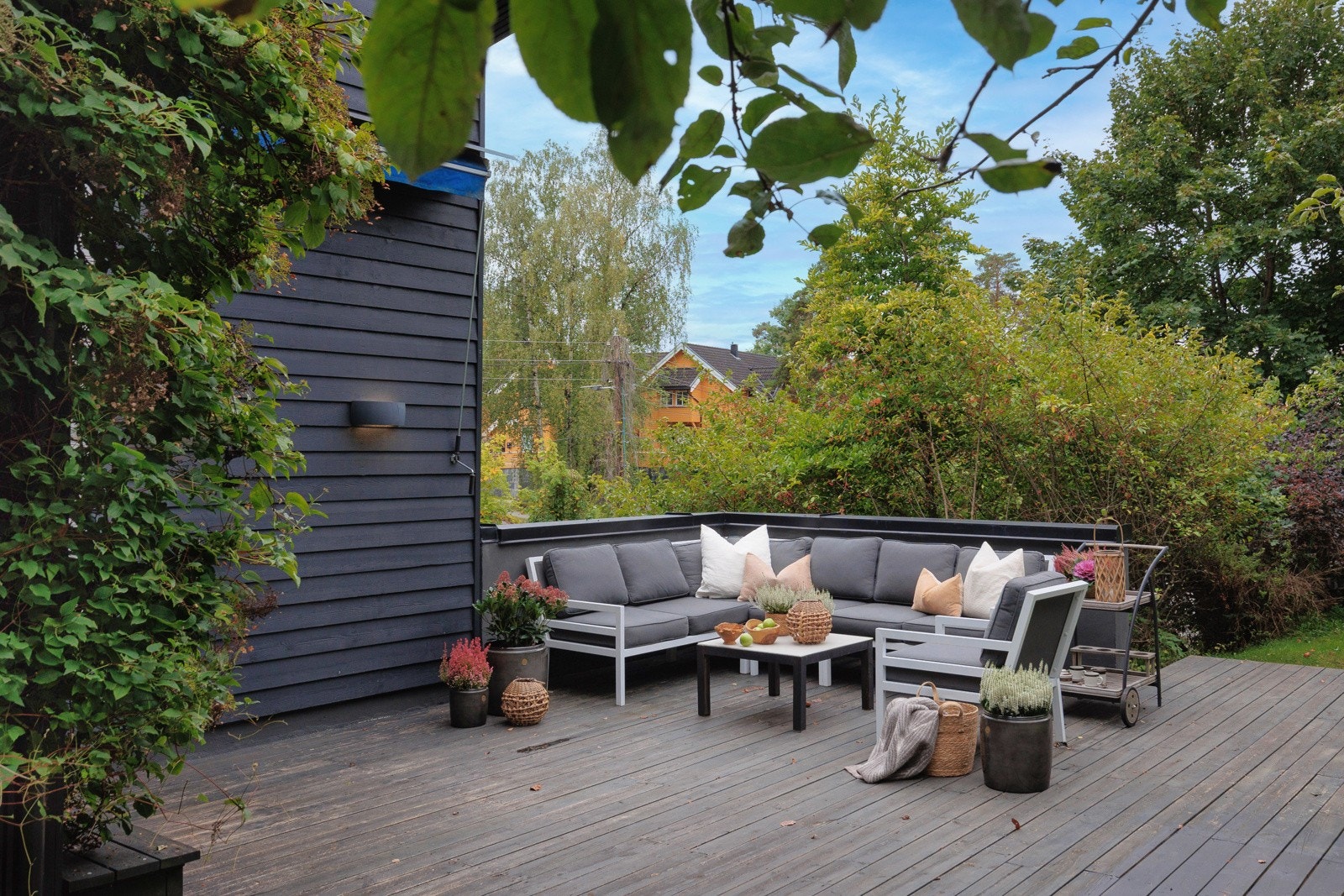 Eneboligen strekker seg over to plan, med flere terrasser og stor hage Galleribilde