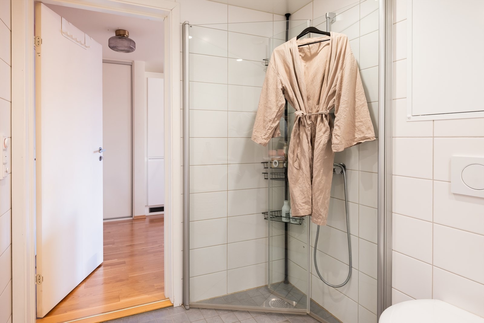 Badet er utstyrt med innfellbare dusjdører, opplegg for vaskemaskin, servant, servantskap og veggmontert wc. Galleribilde