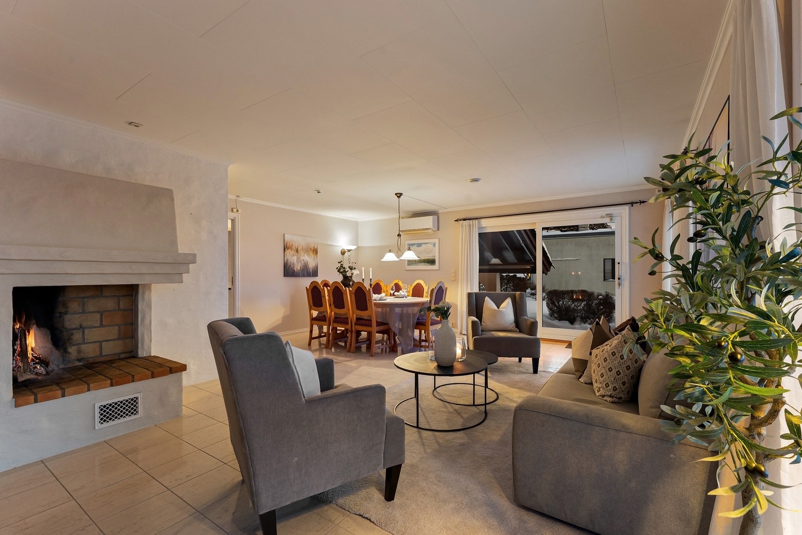 En sentralt plassert peis for vedfyring skaper en lun atmosfære. Galleribilde