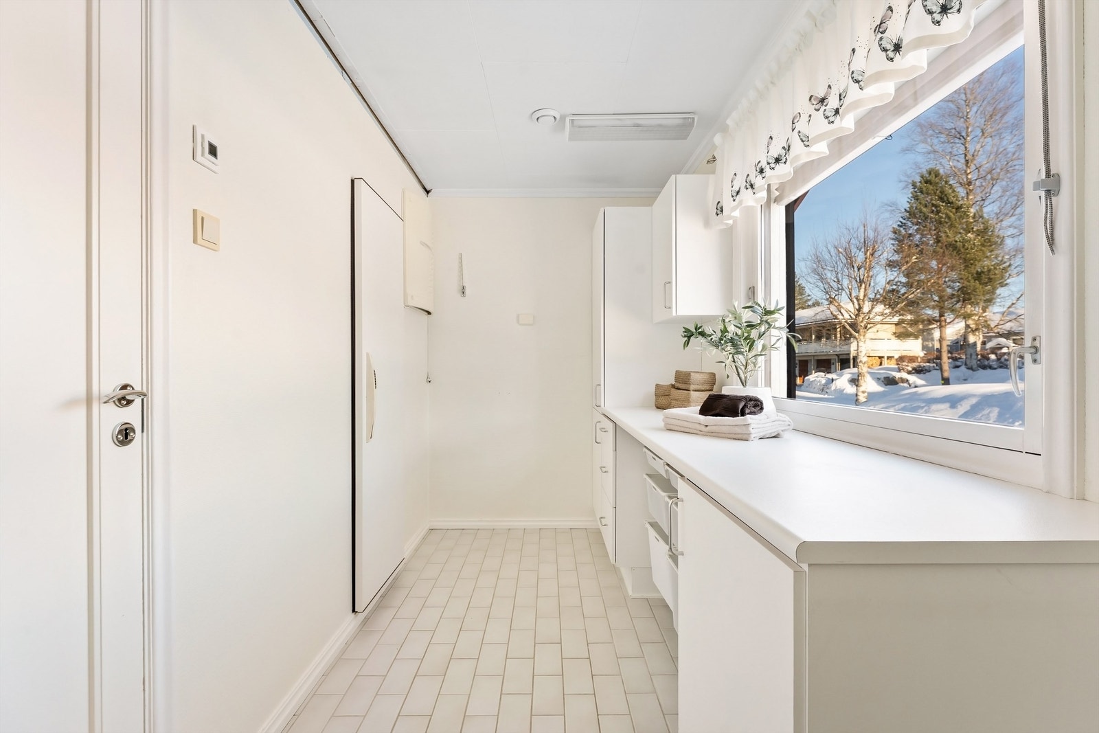 Separat og praktisk vaskerom med flislagt gulv og gulvvarme. Galleribilde