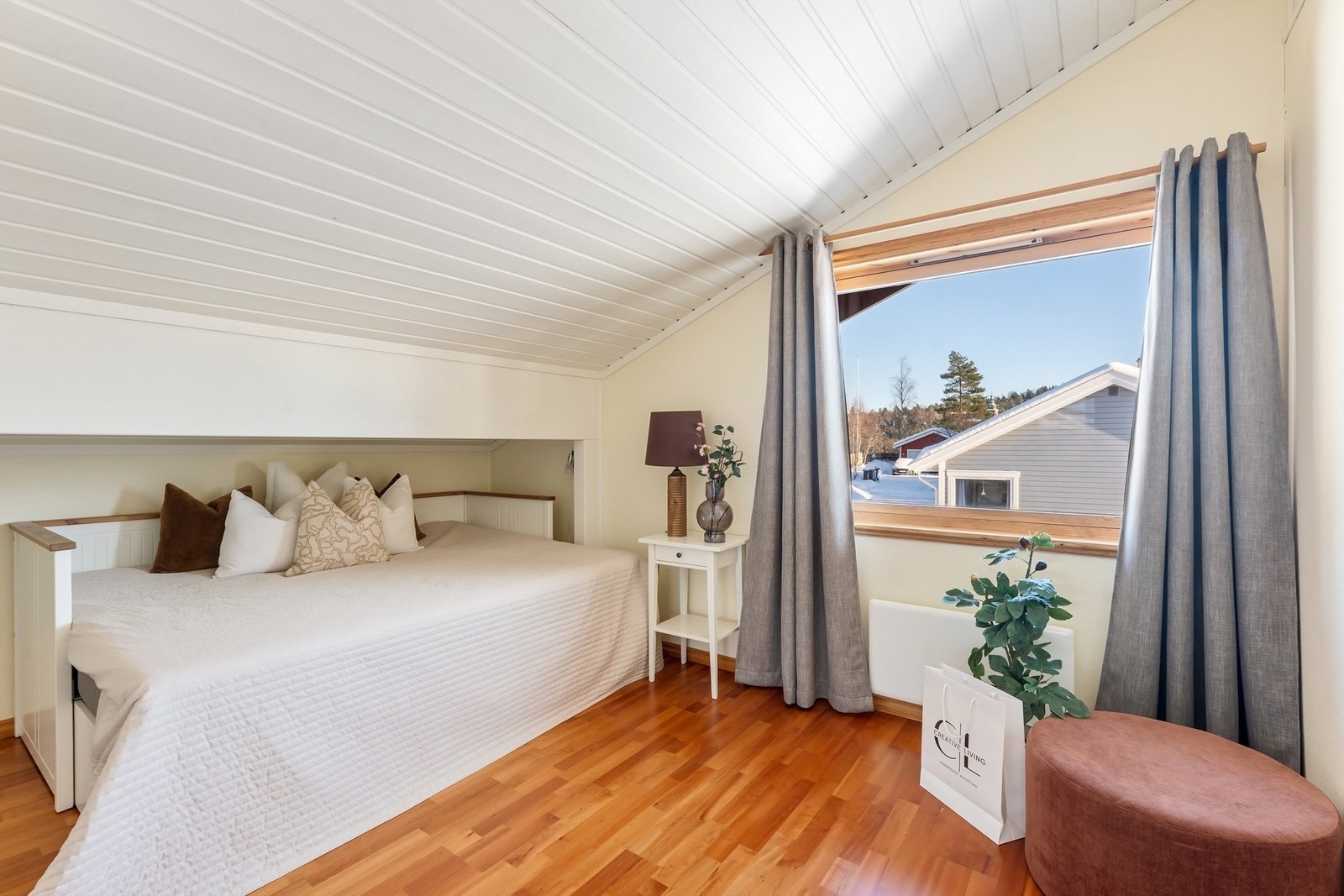 Det ene av to soverom i loftetasjen, med laminatgulv og panel i taket. Galleribilde