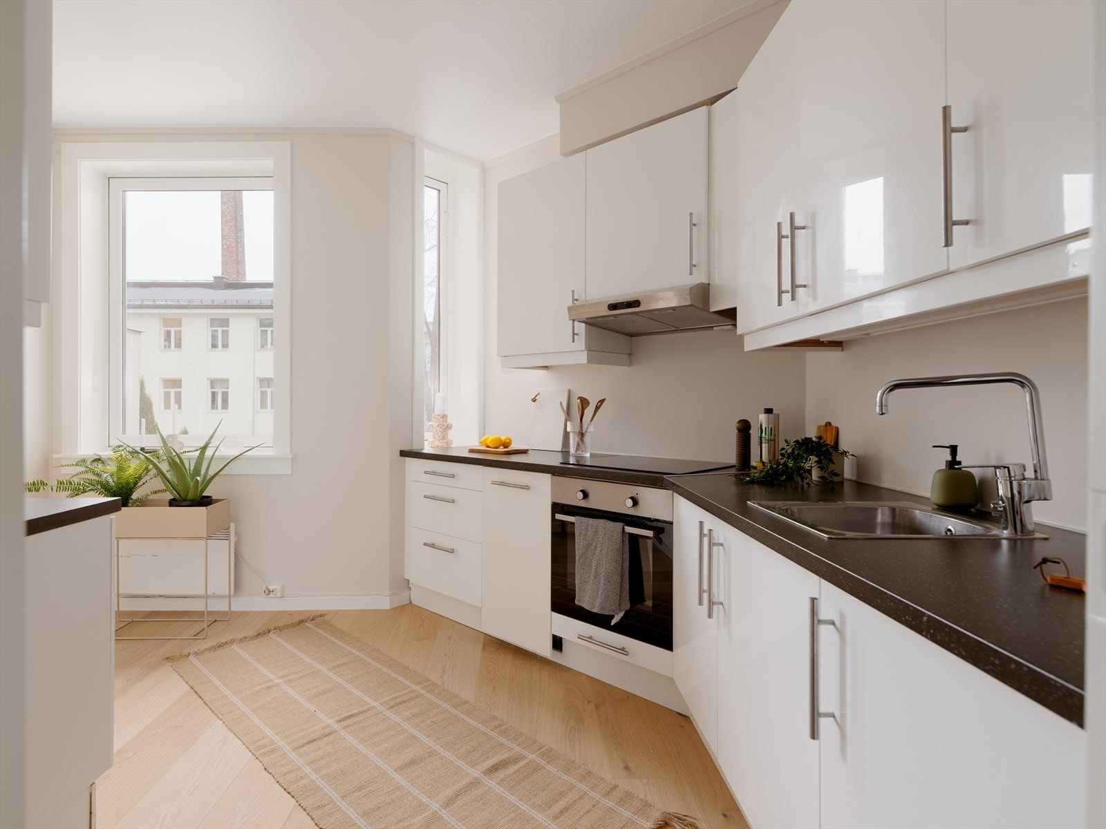 Hvitevarer er integrert, herunder keramisk platetopp, komfyr, smal oppvaskmaskin og kjøleskap med fryserdel. Galleribilde