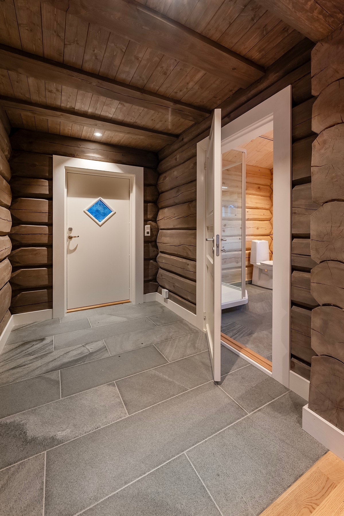 Entréen har flislagt gulv og downlights belysning i taket. Galleribilde