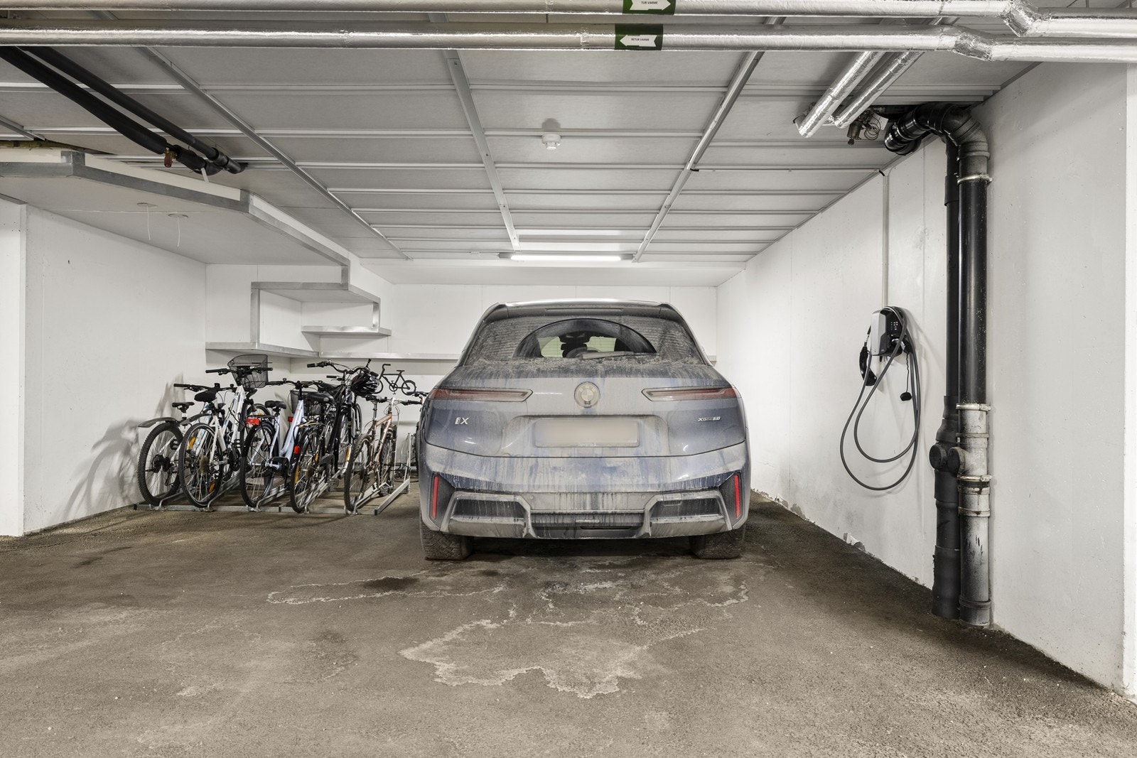 Leiligheten disponerer en bred garasjeplass med installert elbillader. Galleribilde