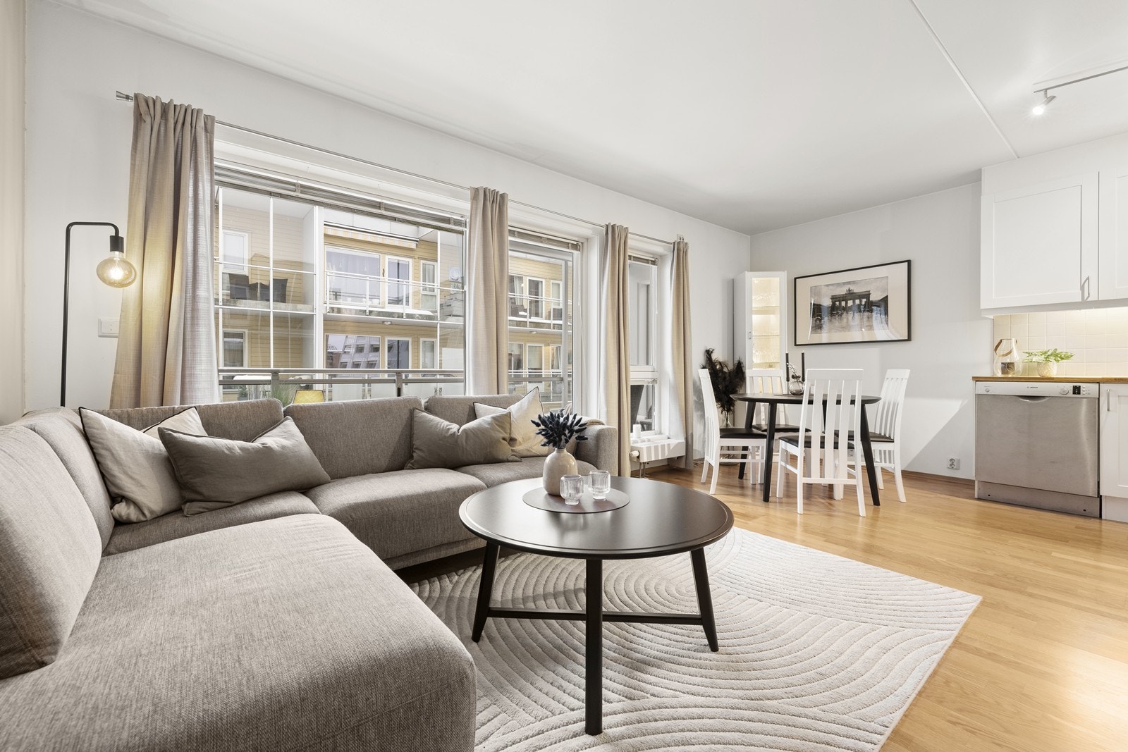 Gjennomgående parkettgulv binder sammen stue og kjøkken til en helhetlig sone. Galleribilde