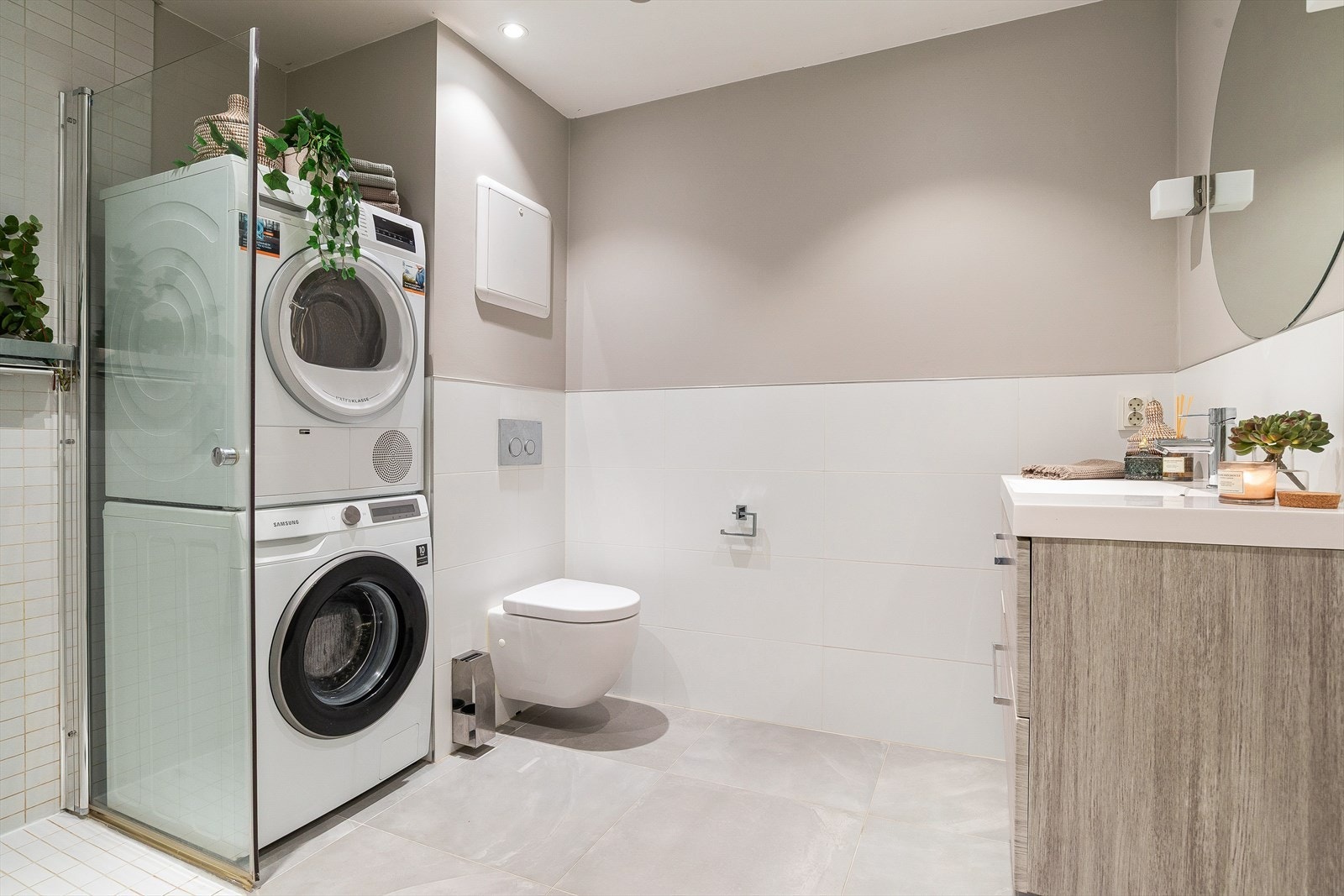 Badet er flislagt og har en praktisk vaskeromsdel med opplegg for vaskesøyle. Galleribilde