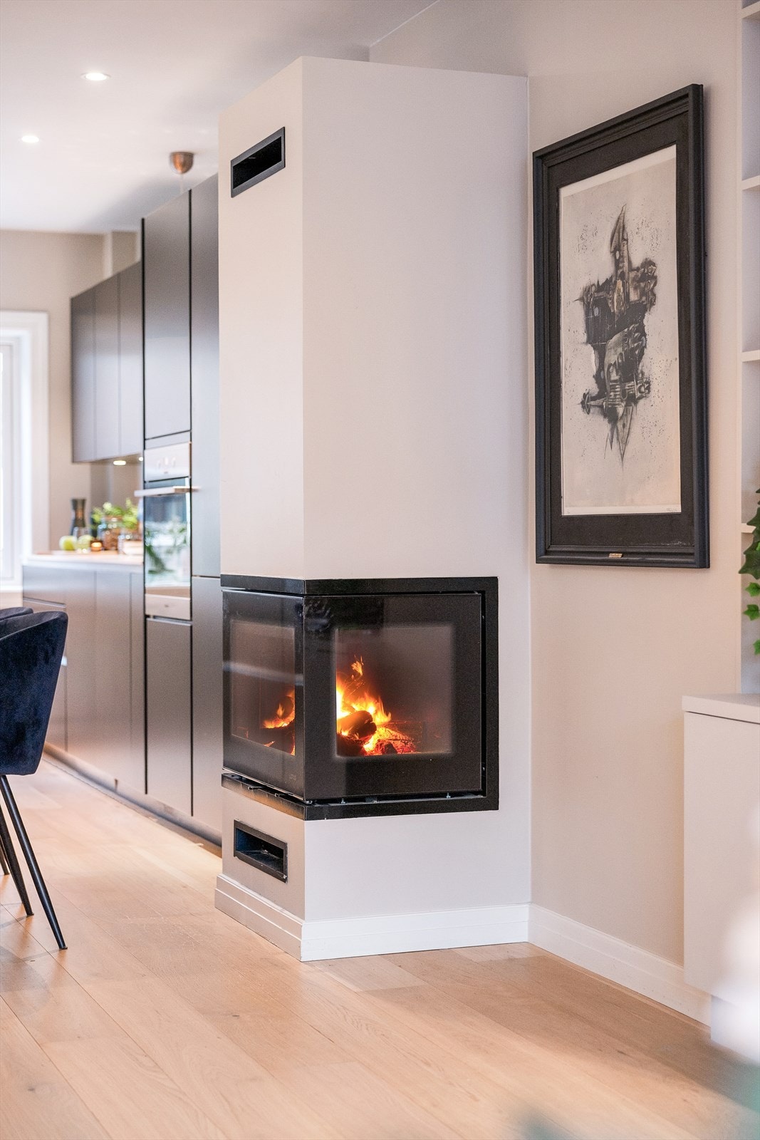 Peisen med glass på to sider skaper en lun atmosfære og fungerer som en romdeler. Galleribilde