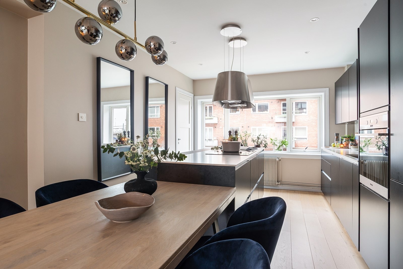 Kjøkkeninnredningen har slette, mørke fronter og integrerte hvitevarer. Galleribilde