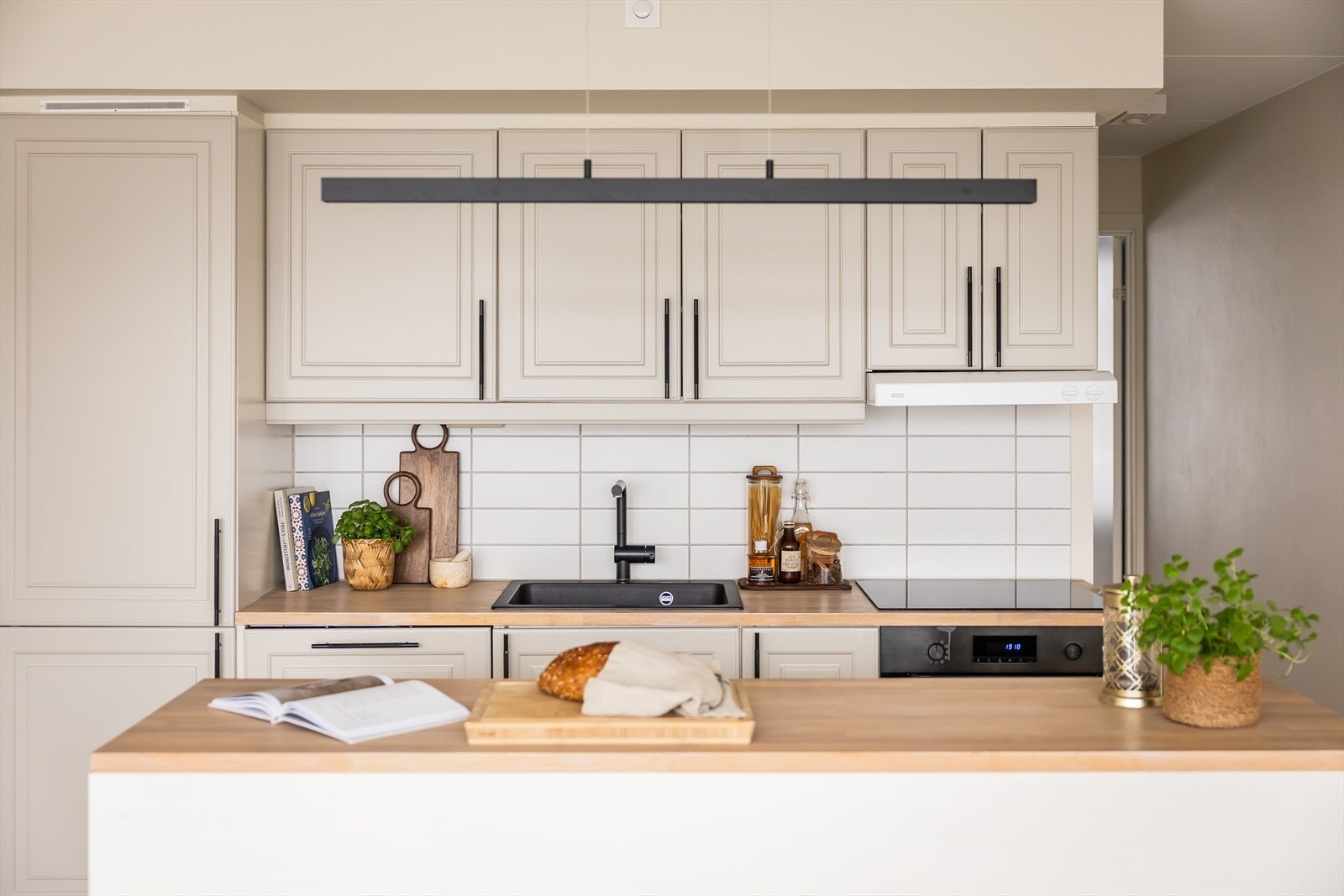 Kjøkkenet har praktisk kjøkkenøy og overskap, samt integrerte hvitevarer bestående av kjøl/fryseskap, oppvaskmaskin, stekeovn og induksjonstopp. Galleribilde