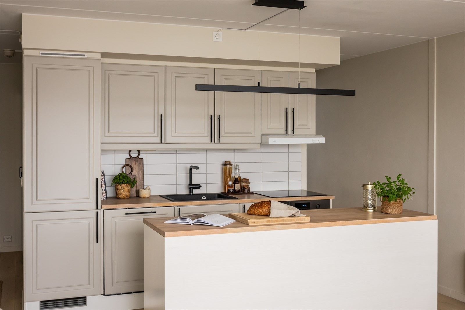 Moderne kjøkken med rikelig skap- og benkeplass, utformet med profilerte fronter og heltre benkeplate med nedfelt vask. Galleribilde