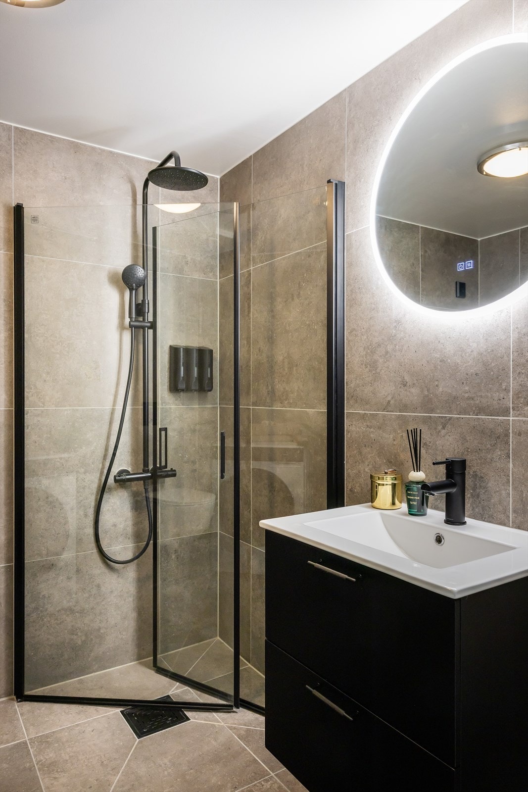 Badet er innredet med vegghengt klosett, servant nedfelt i innredning og dusjhjørne med svingbare glassdører. Galleribilde