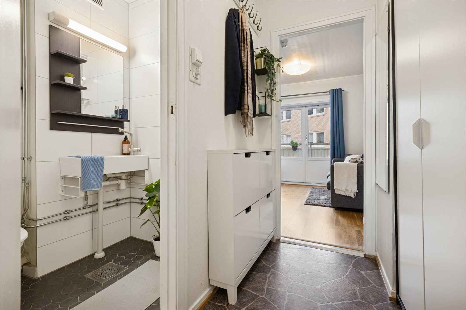 Leiligheten nås via felles trappegang, og man trer inn i en innbydende entré med plassbygd garderobeløsning som gir praktisk oppbevaring av yttertøy og sko. Galleribilde