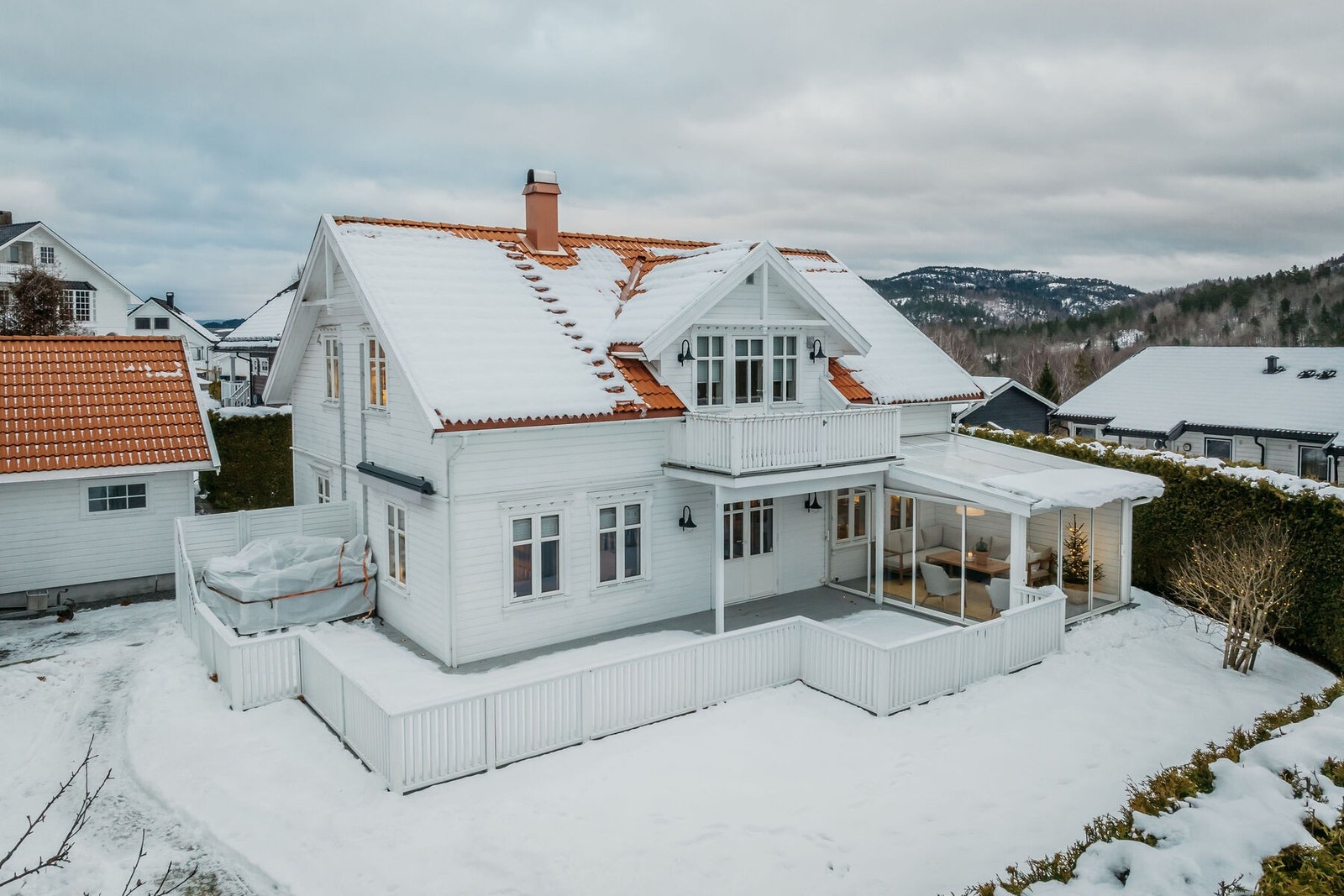 Huset ligger på en flott hjørnetomt, opparbeidet med trær, busker, gressplen og diverse beplantning. Galleribilde
