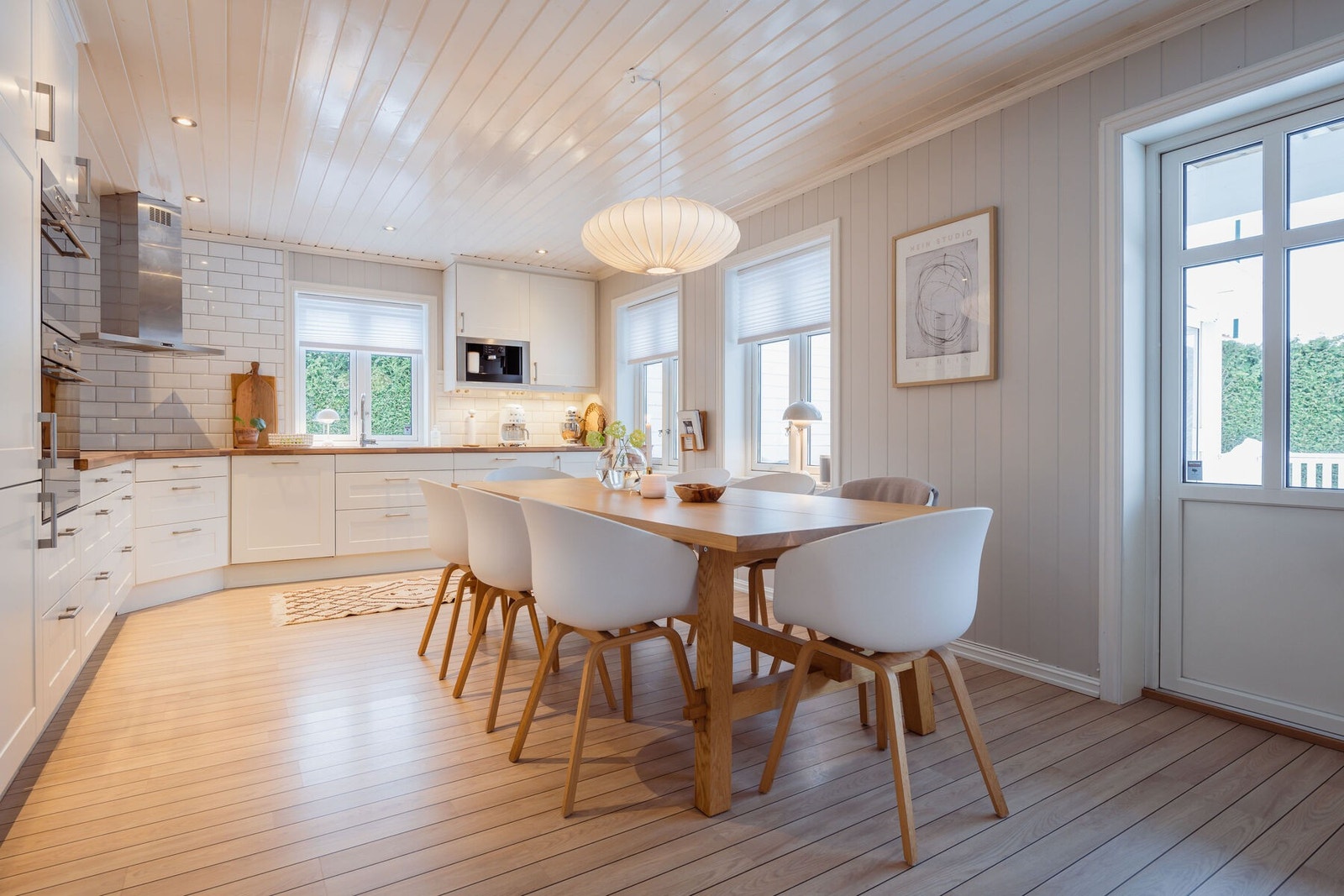 Kjøkkenet er et flott samlingssted, der laminat på gulvet kombineres med panelplater malt i en dus og delikat gråtone. Galleribilde