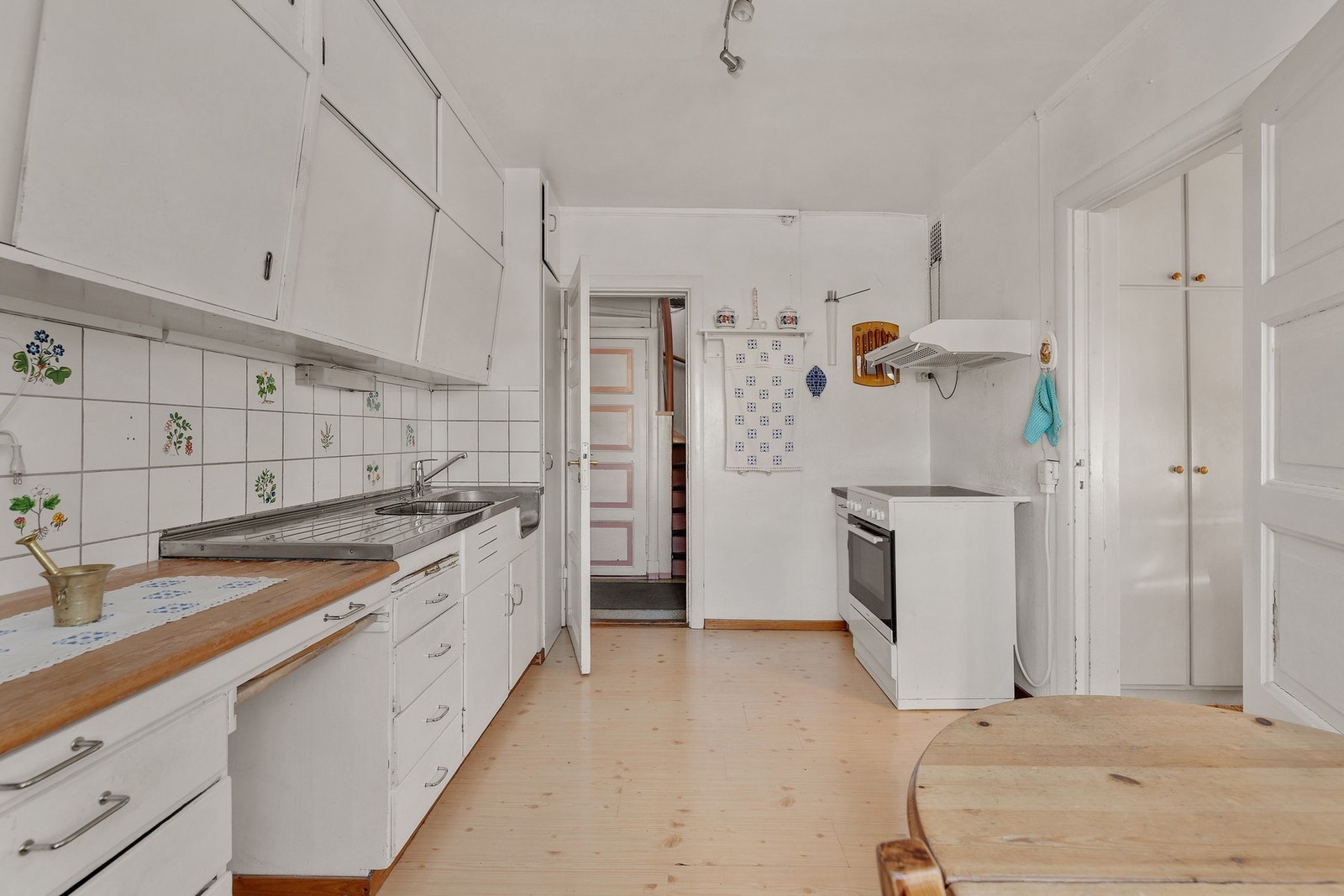 Benkeplater består av heltre og laminat, og kjøkkenet er utstyrt med benkebeslag i rustfritt stål med både utslagskum og kum. Galleribilde