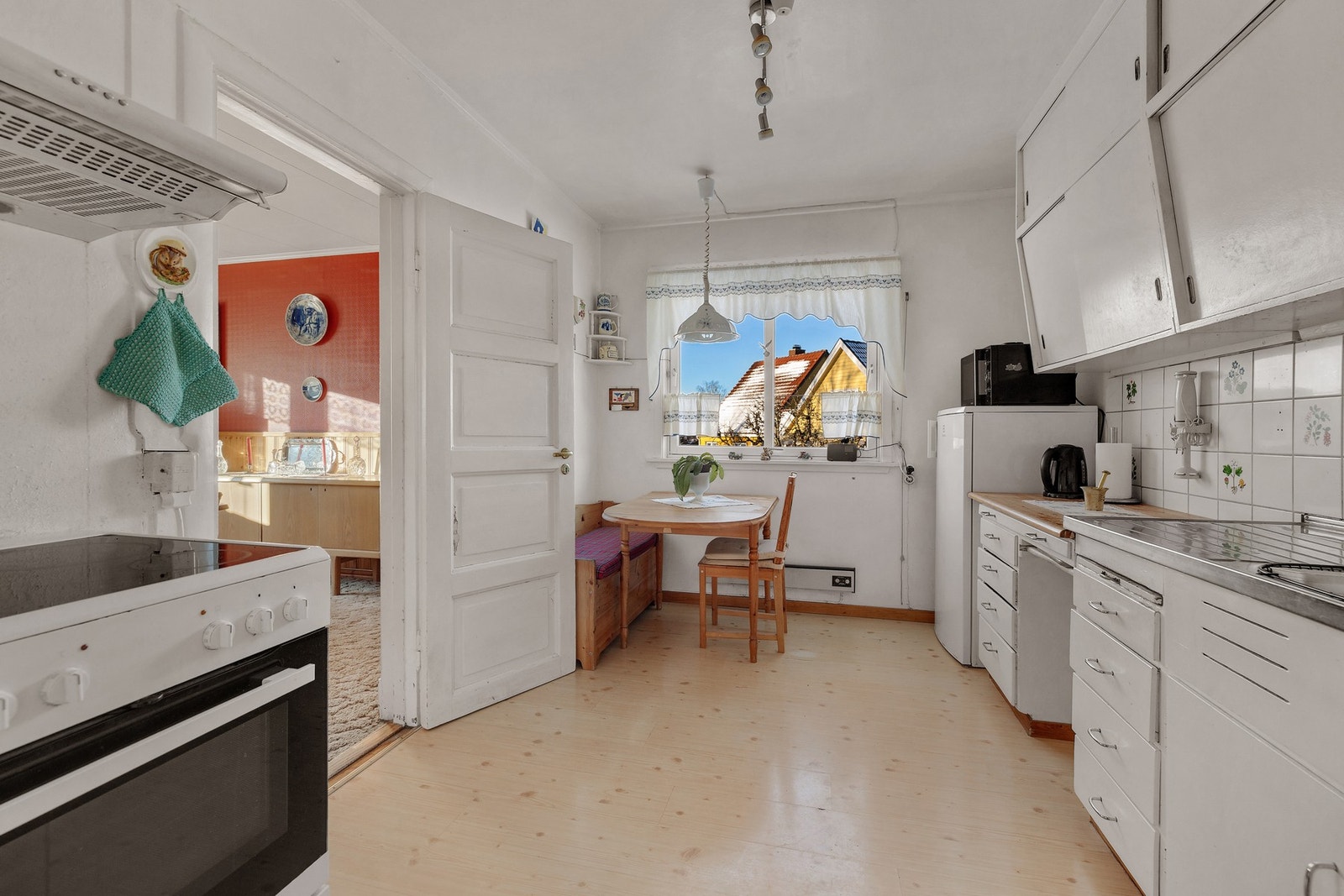 Kjøkkenet har en eldre kjøkkeninnredning med glatte, malte fronter. Galleribilde