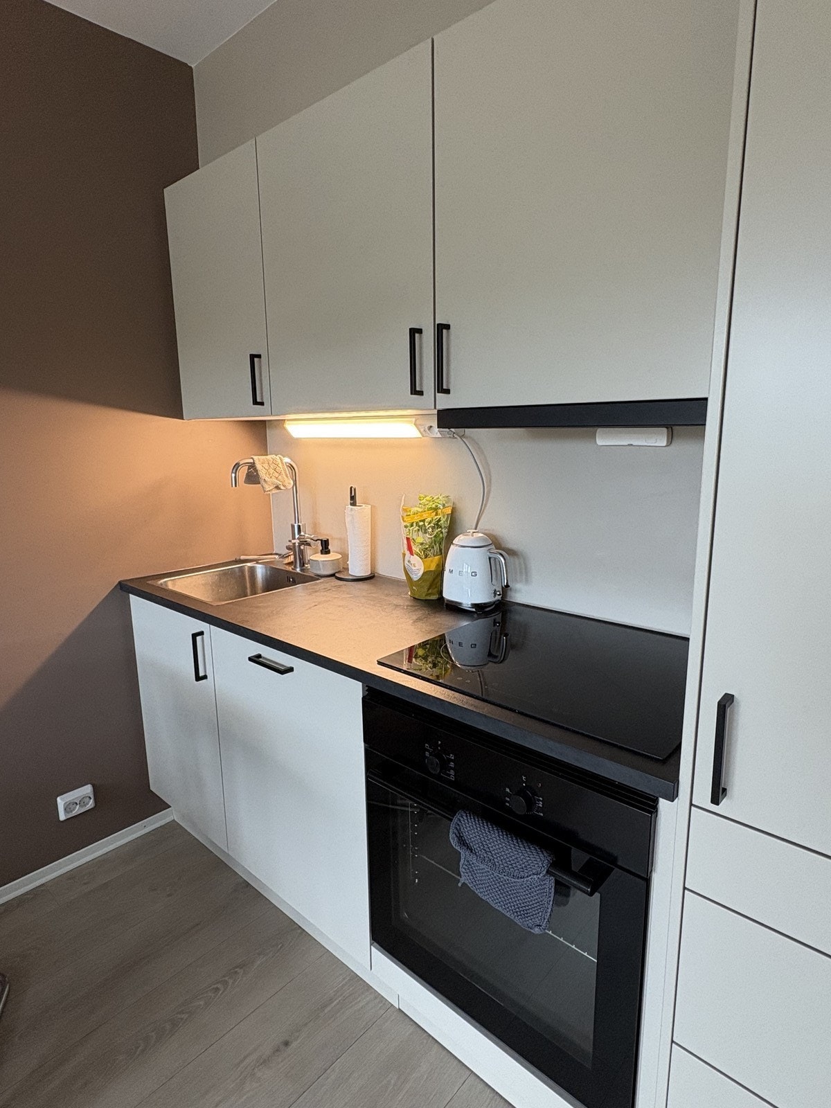 Lyst og pent kjøkken med integrerte hvitevarer Galleribilde