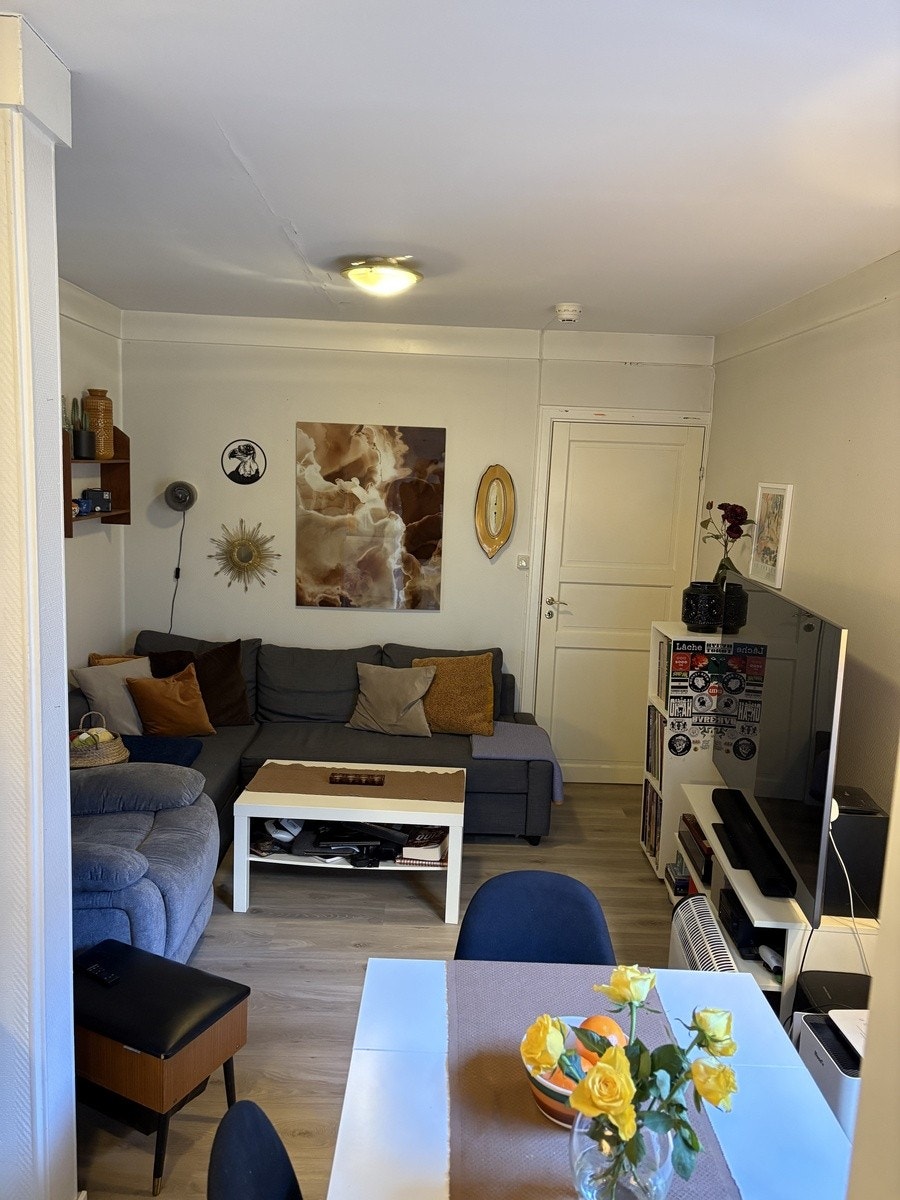 Leilighetens oppholdsrom - et naturlig skille mellom stue og kjøkken i en åpen løsning Galleribilde